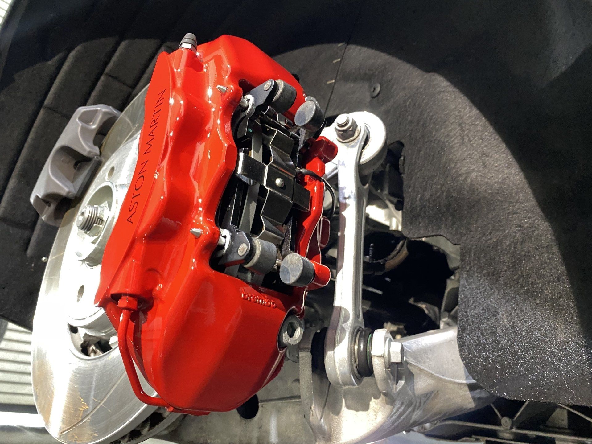 A close up of a red brake caliper on a car