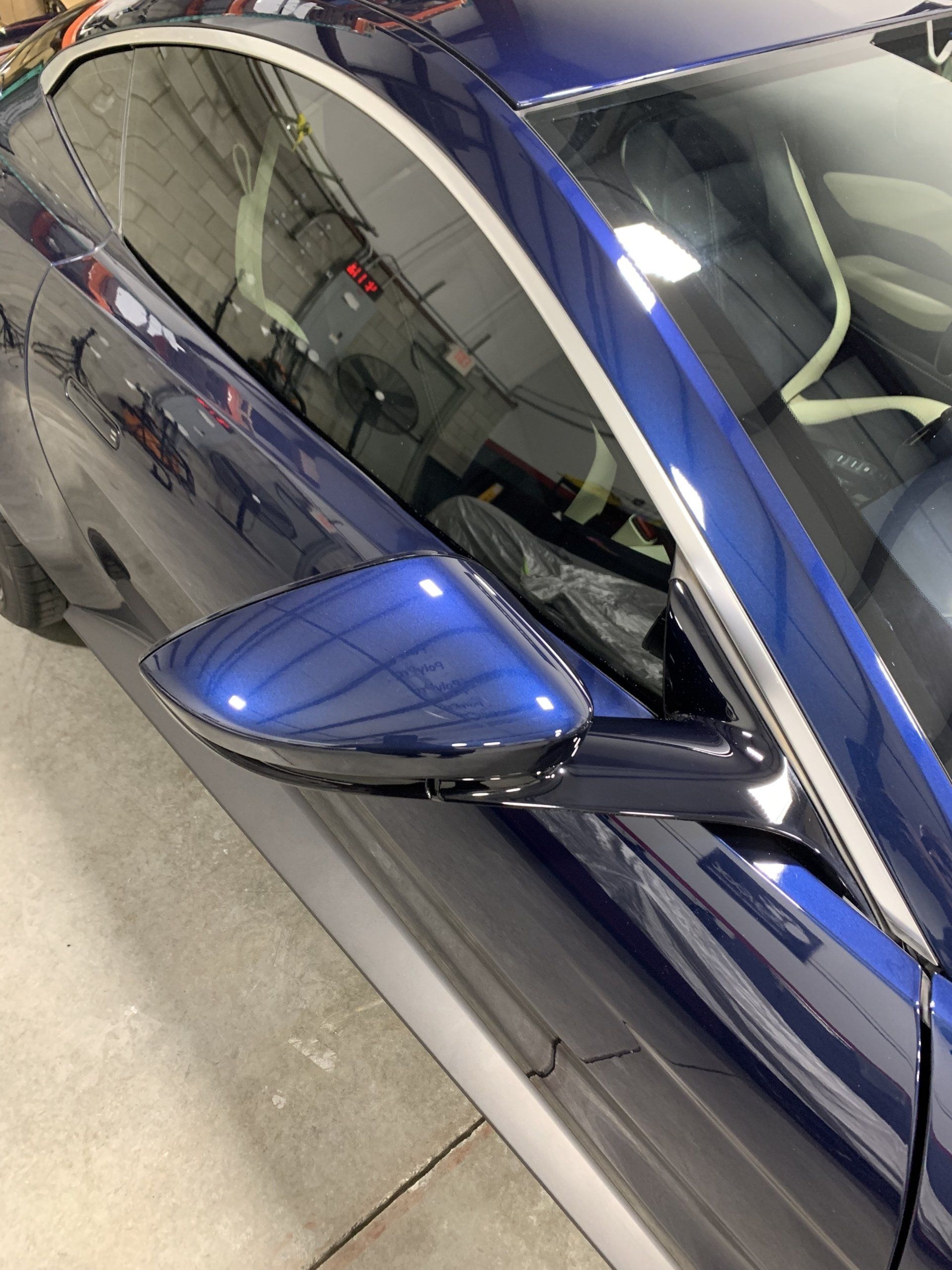 A blue sports car is parked in a garage