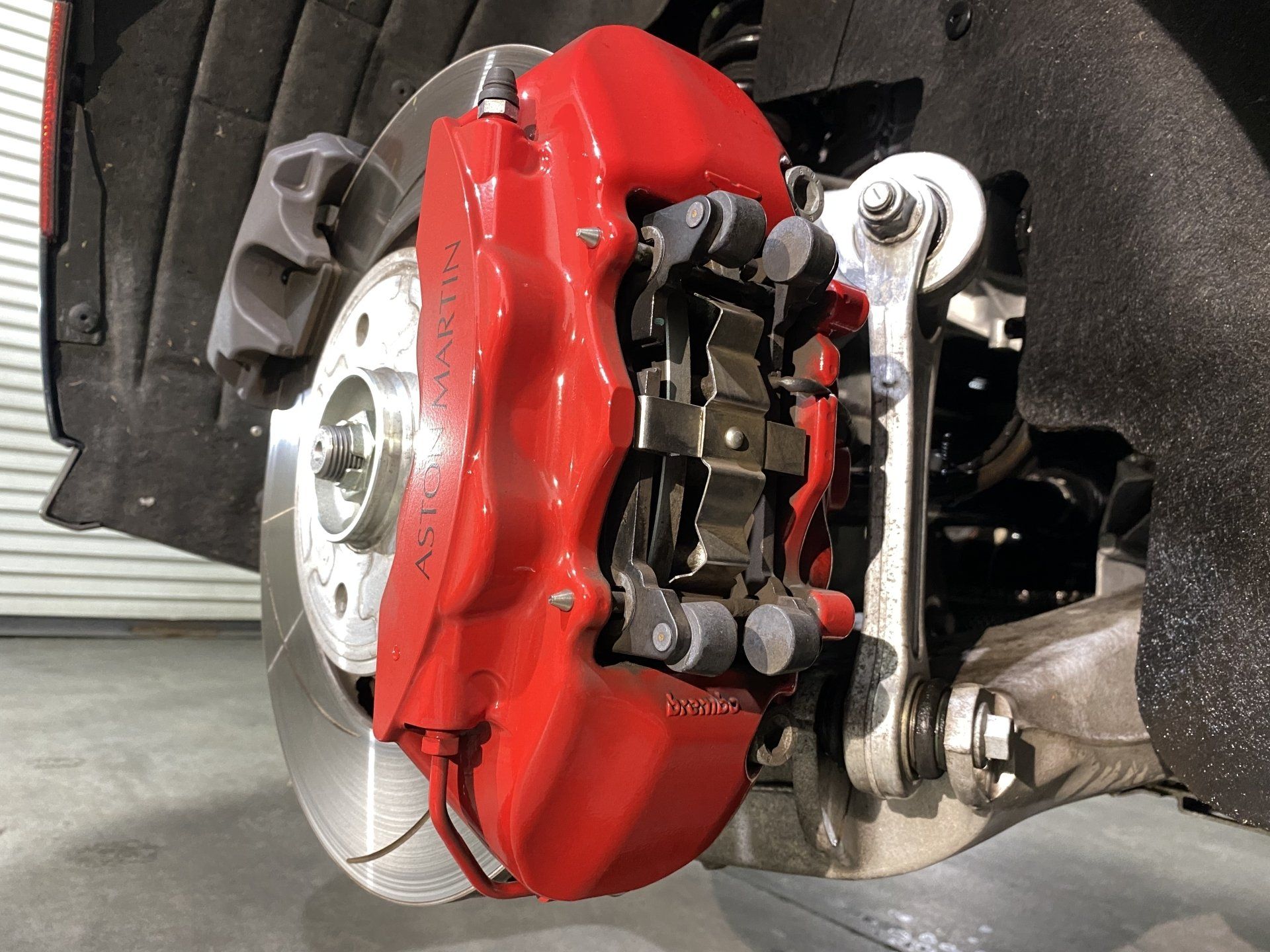 A close up of a red brake caliper on a car