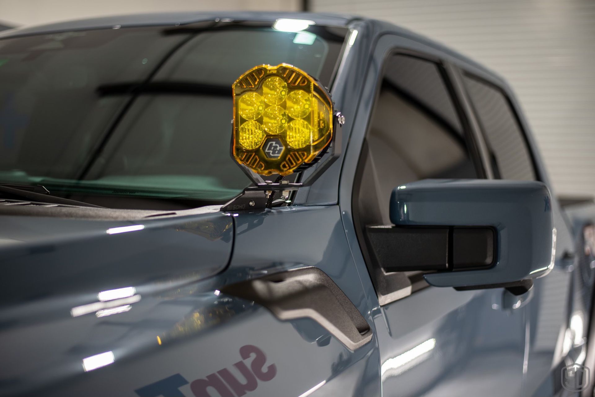 A close up of a truck with a yellow light on the hood.