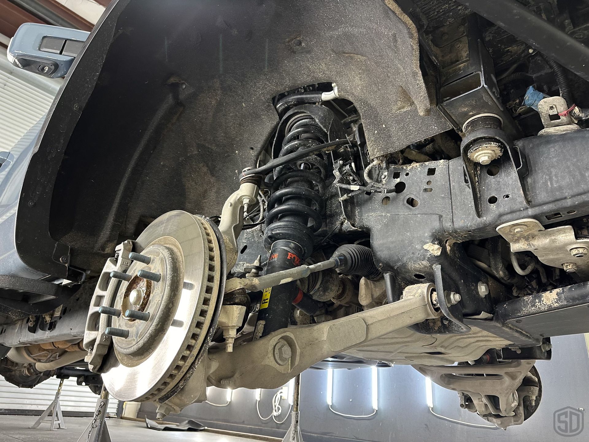 A close up of the underside of a car with a brake disc