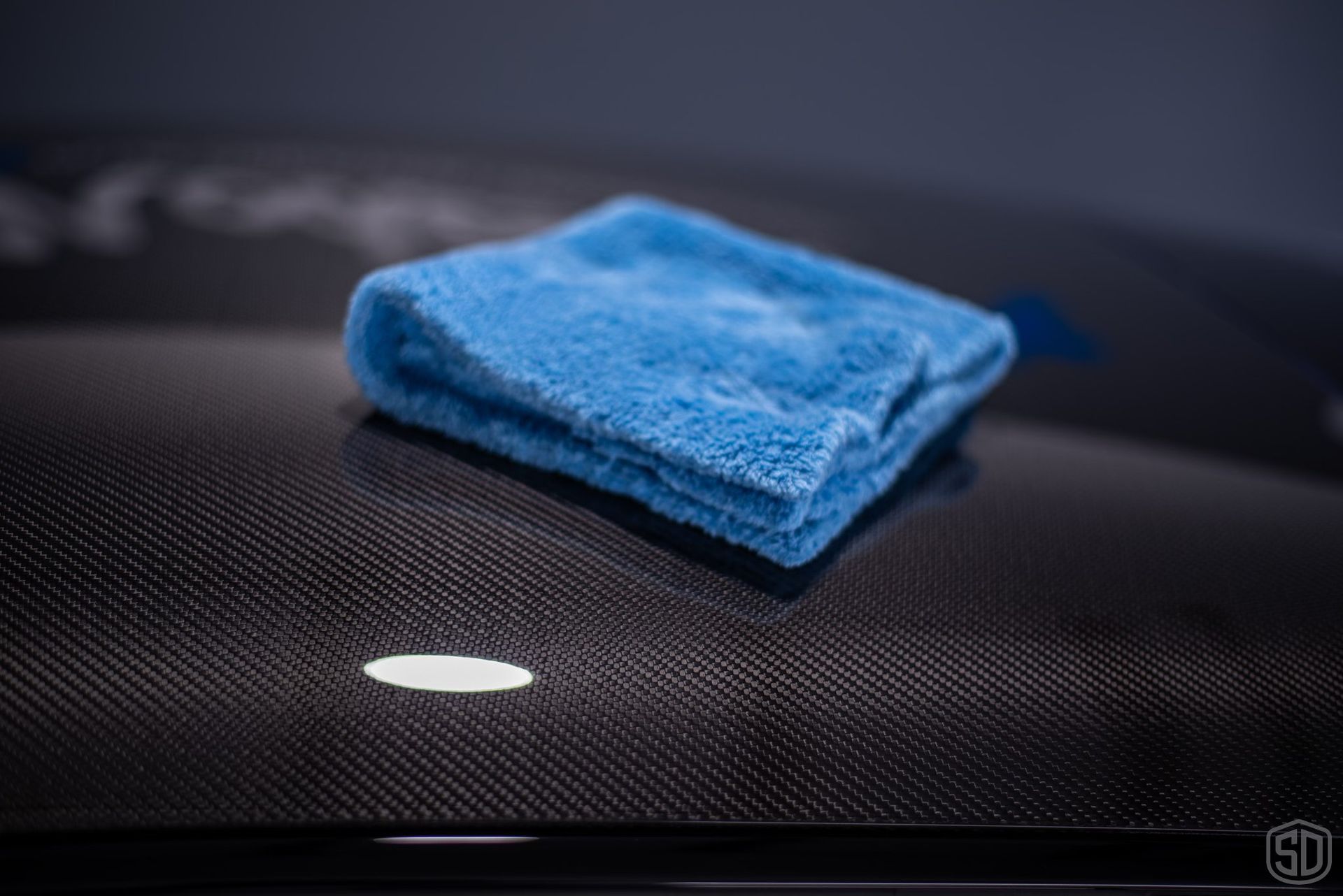 A blue towel is sitting on top of a black surface.