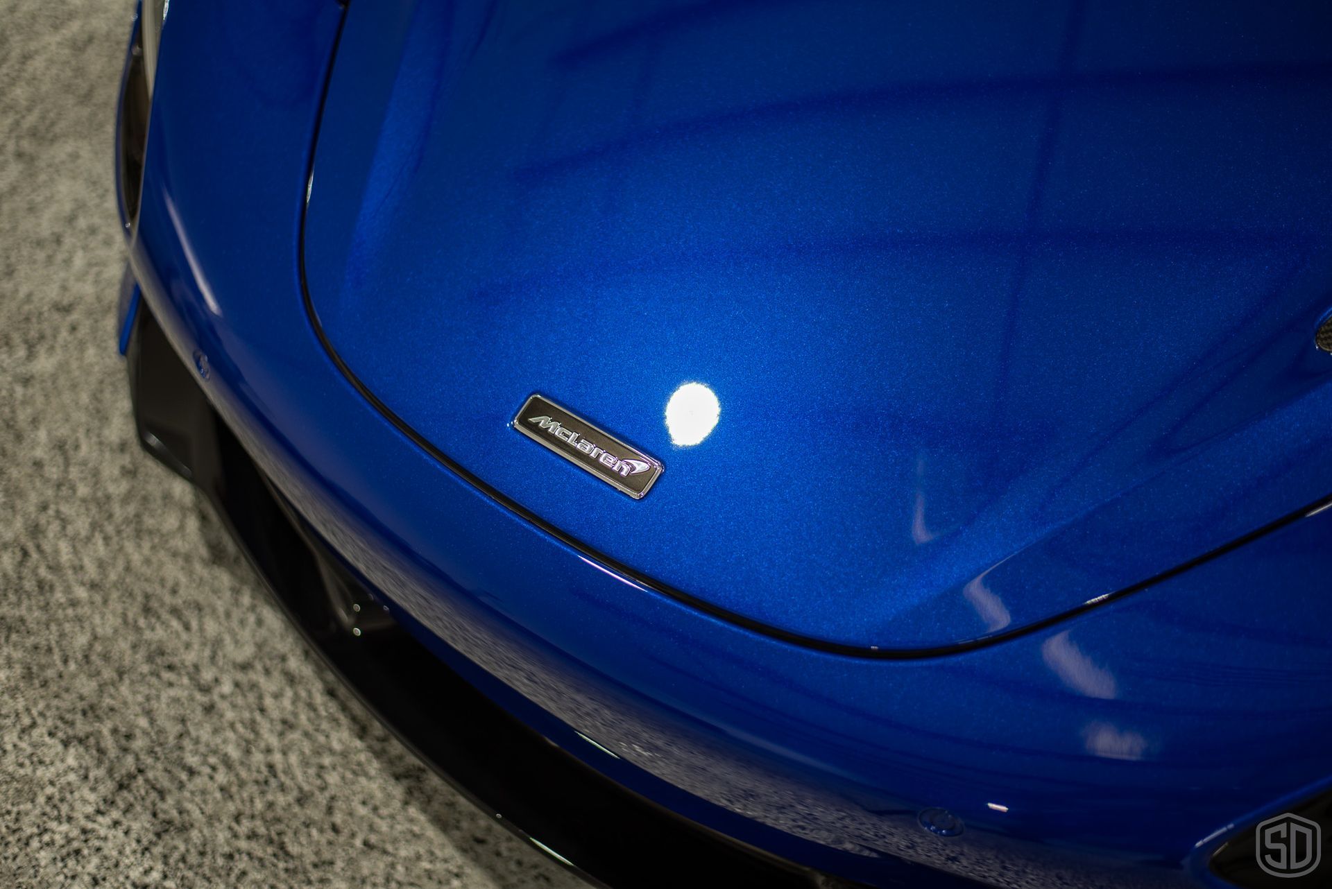 A close up of the front end of a blue sports car.