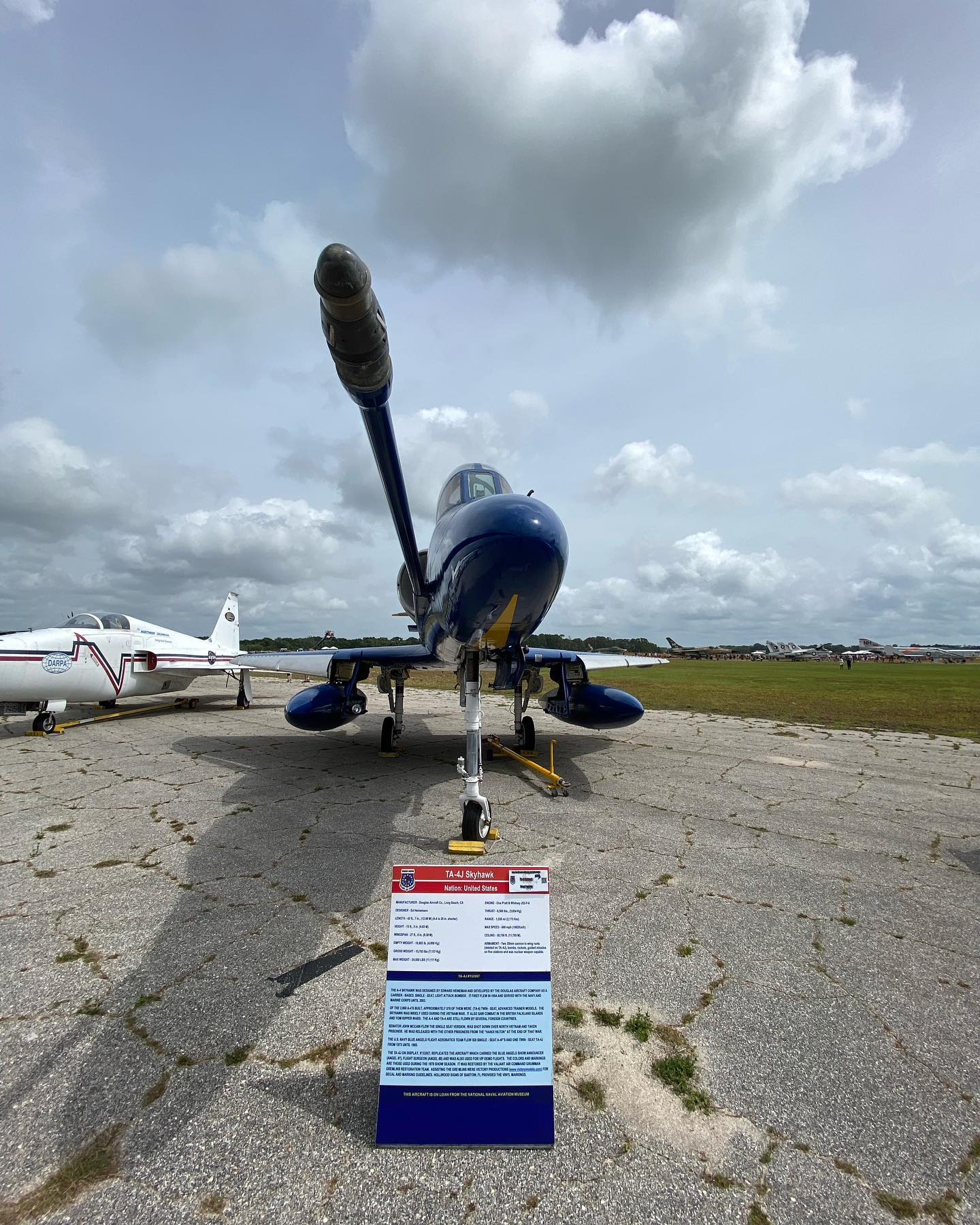 A blue and yellow fighter jet is parked on a runway.