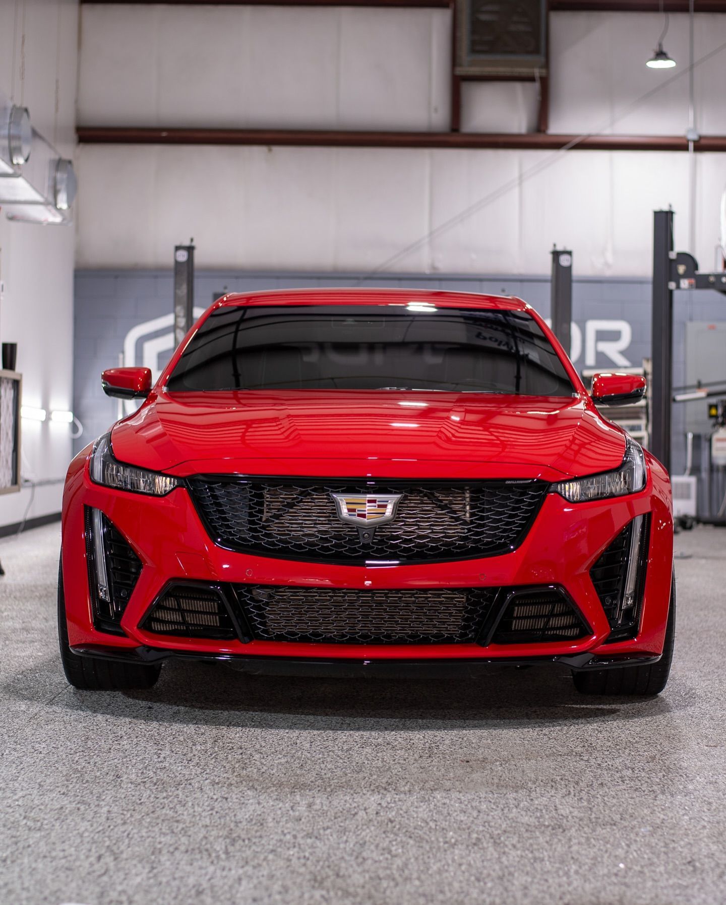 A red cadillac is parked in a garage.