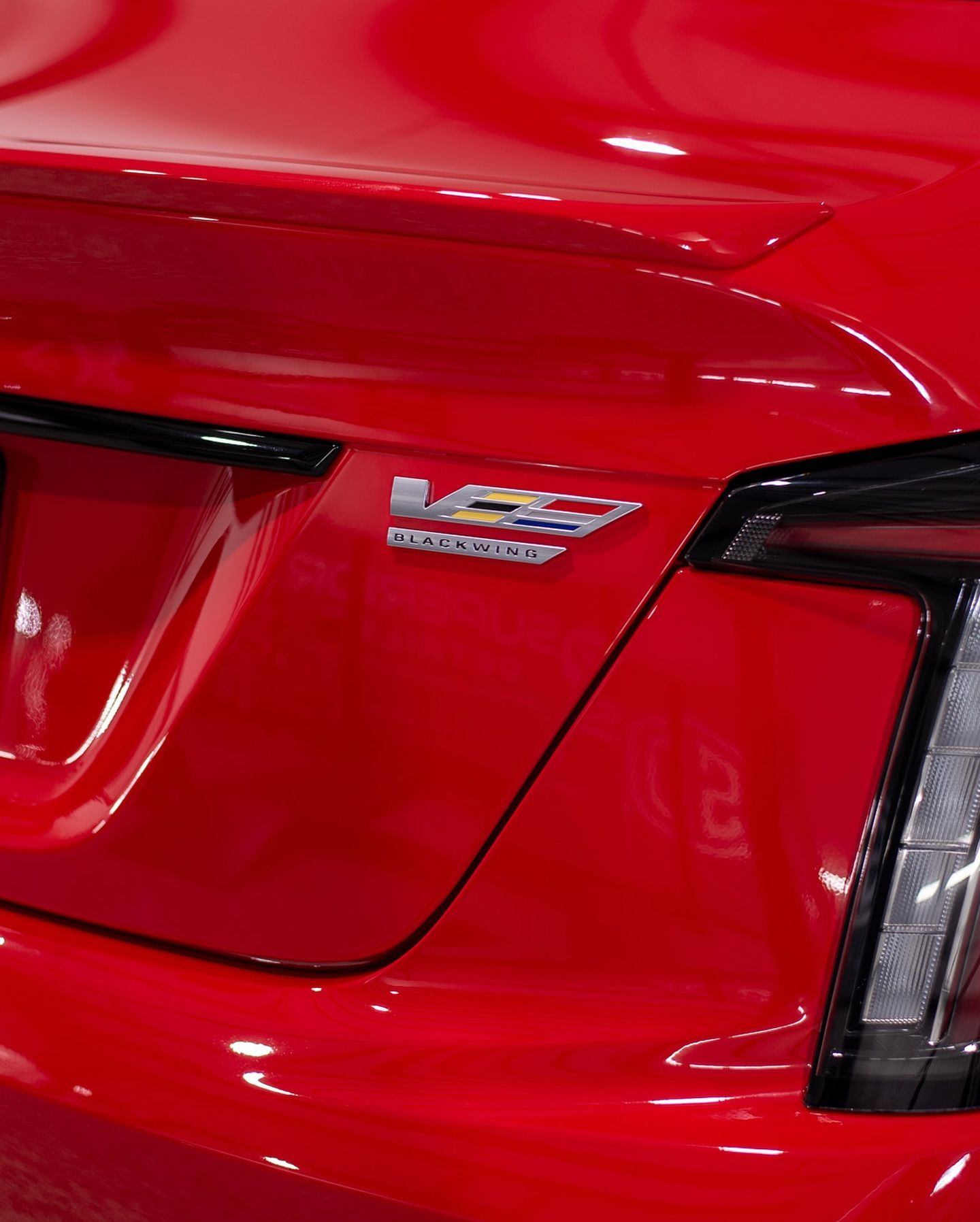 A close up of a red car with a cadillac emblem