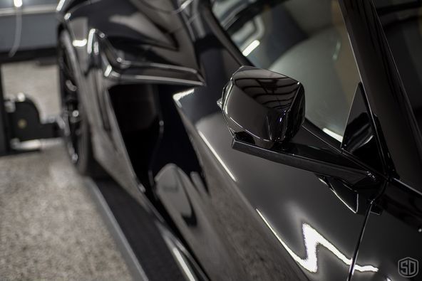 A black lamborghini aventador is parked in a garage.