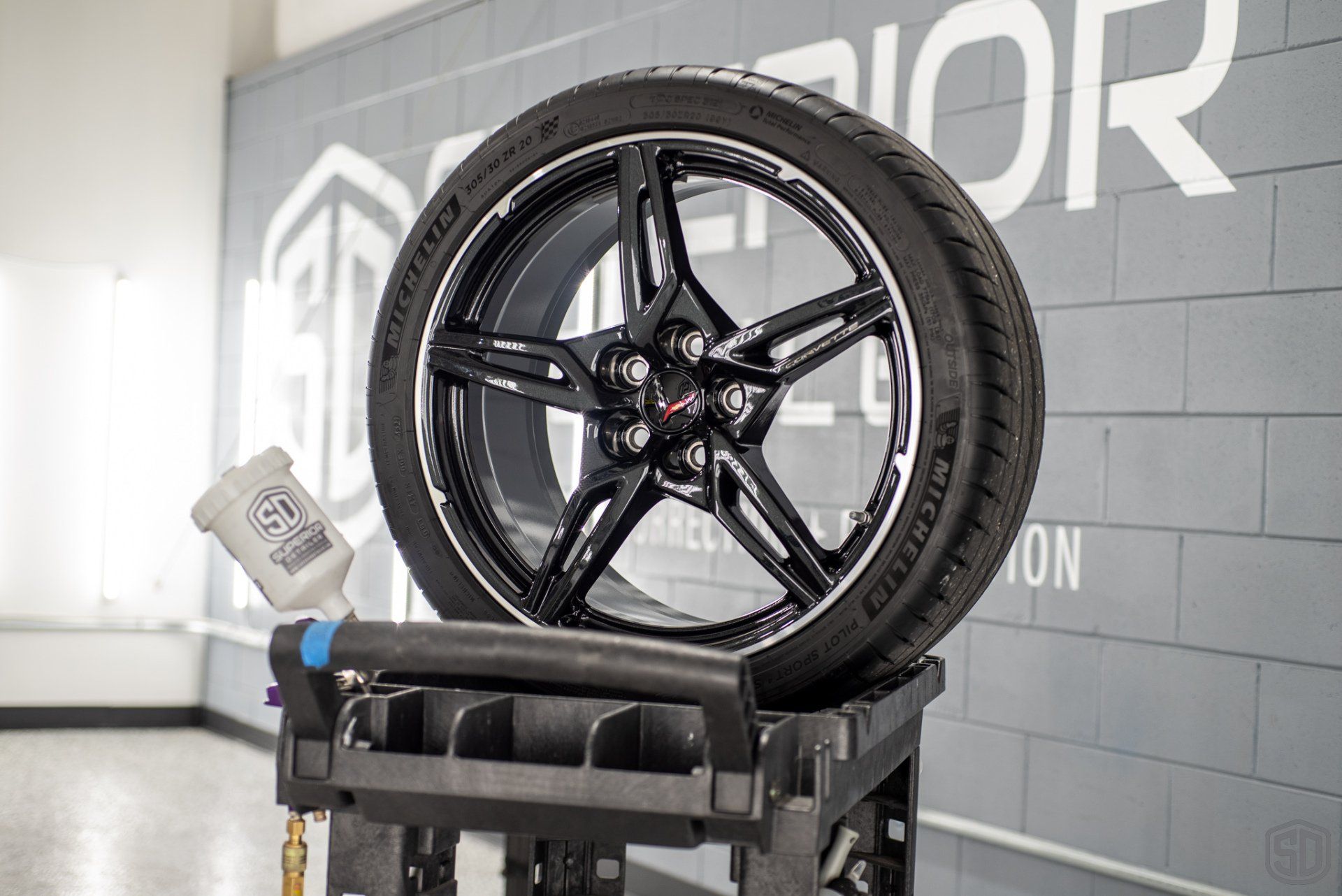 A tire is sitting on top of a cart in a garage.