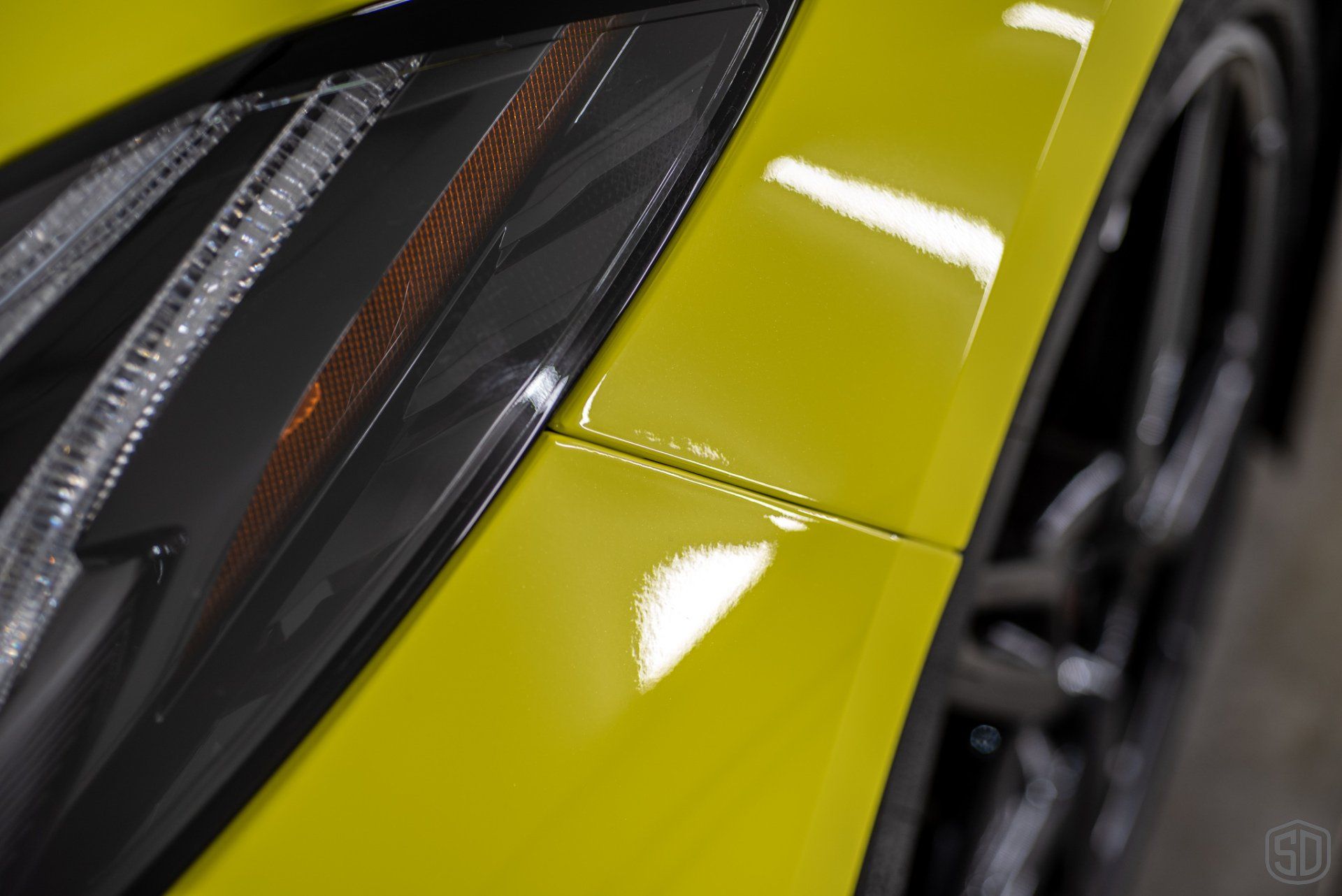 A close up of a yellow car 's headlight
