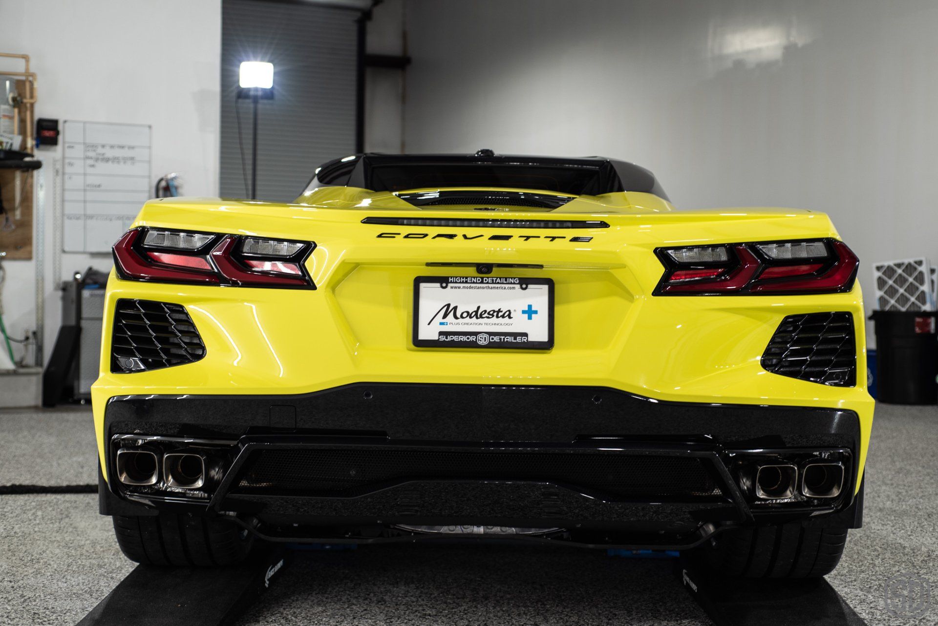 A yellow sports car is parked in a garage.