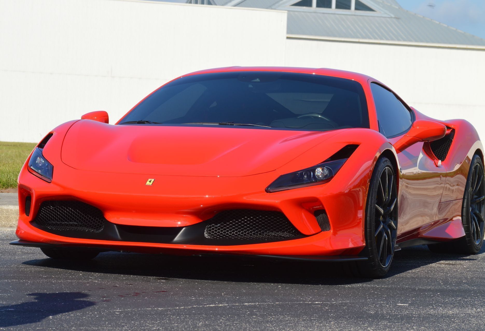 A red sports car is parked on the side of the road.