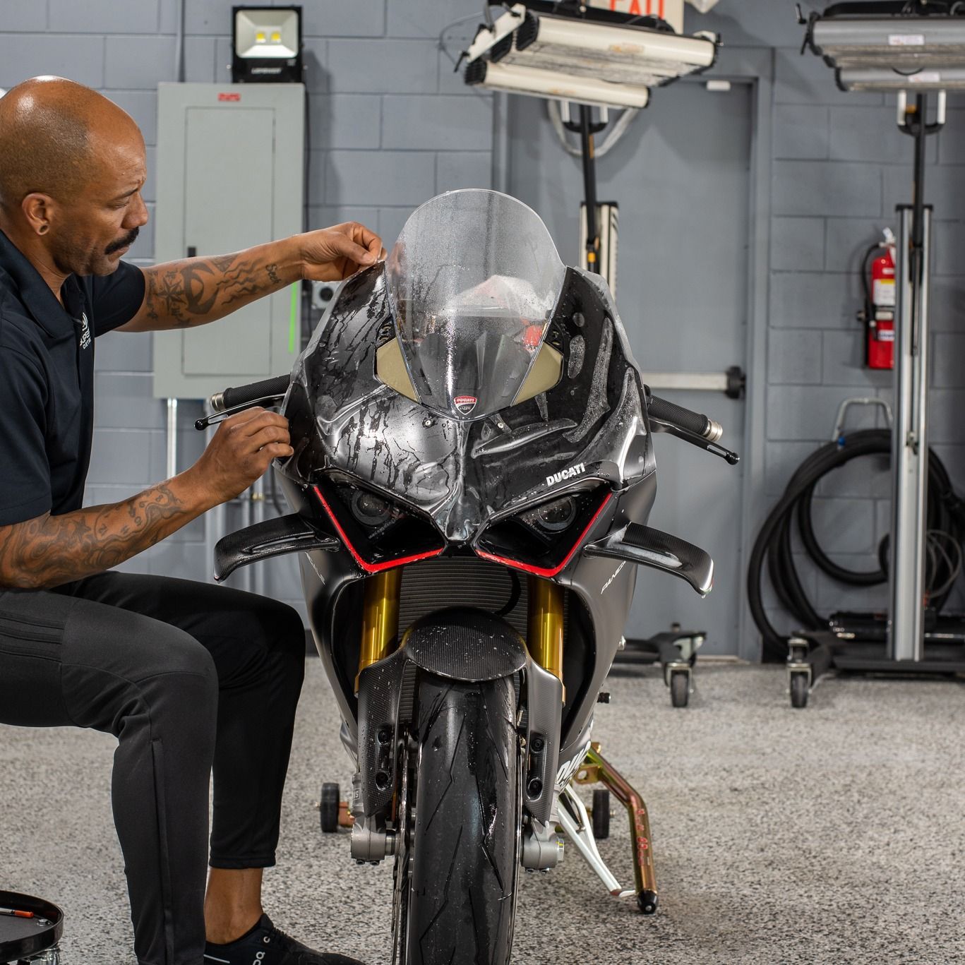 A man is working on a motorcycle in a garage