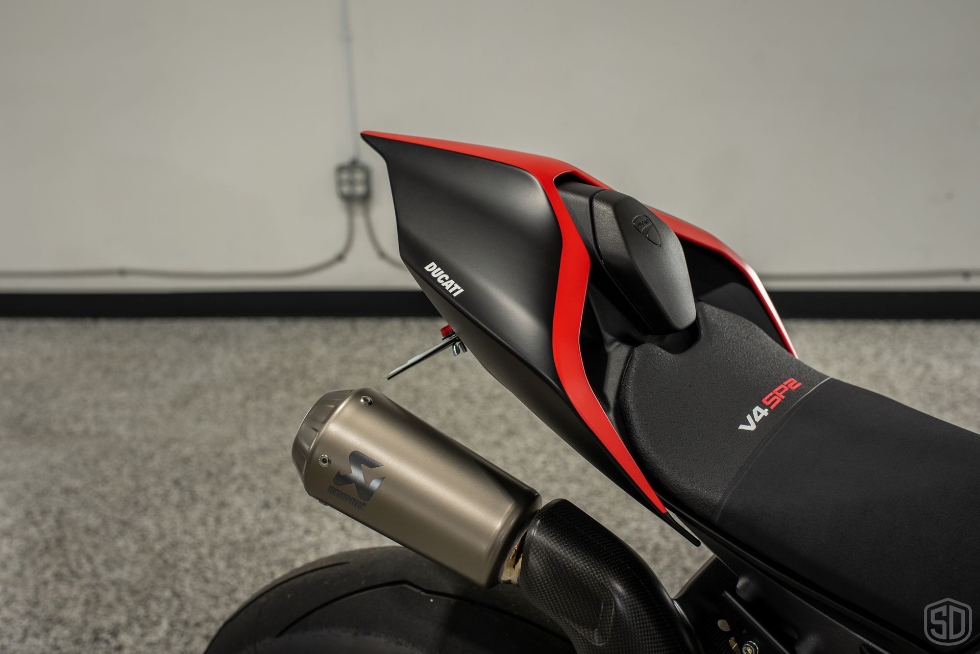 A black and red motorcycle is parked in a garage.