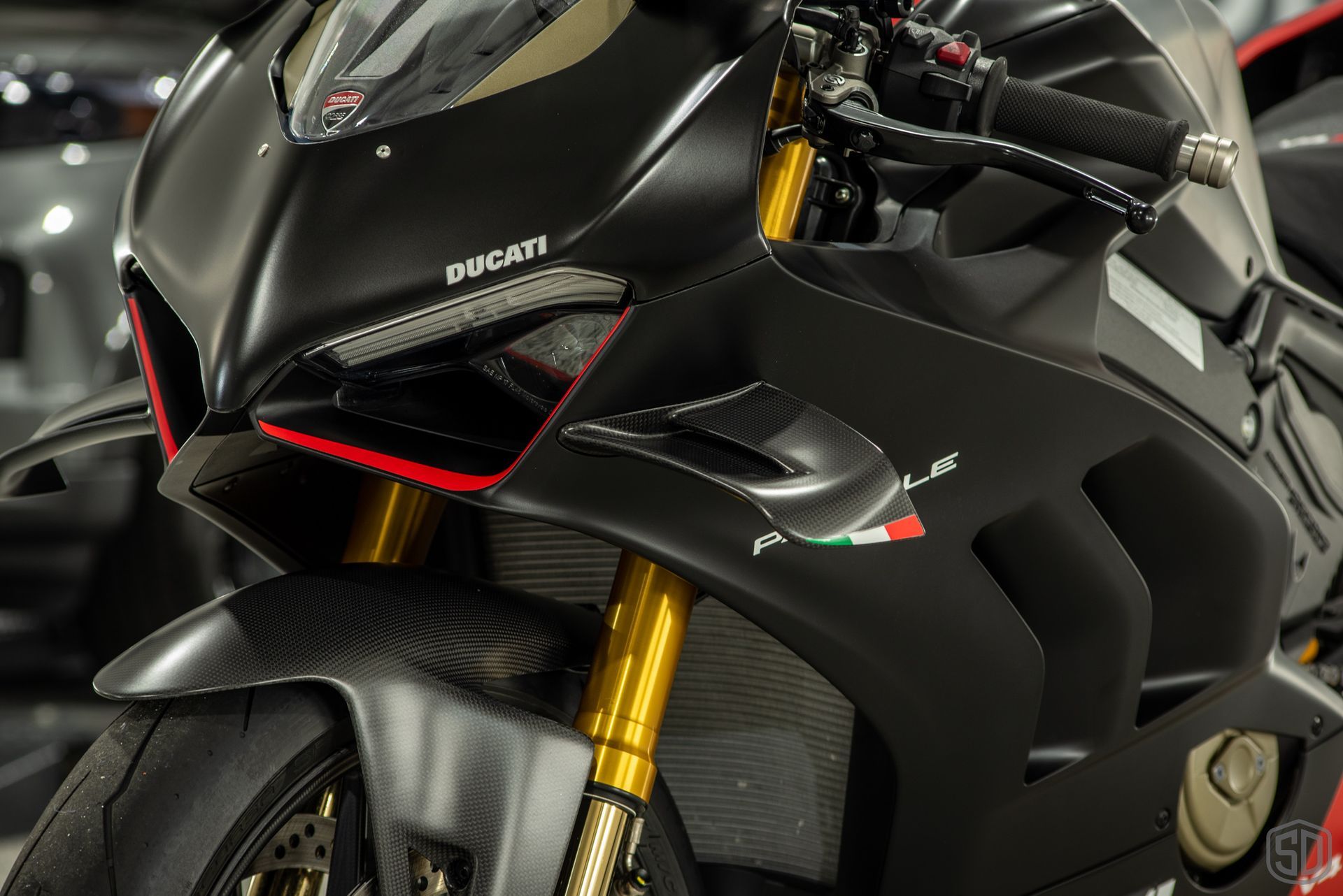 A black ducati motorcycle is parked in a garage.