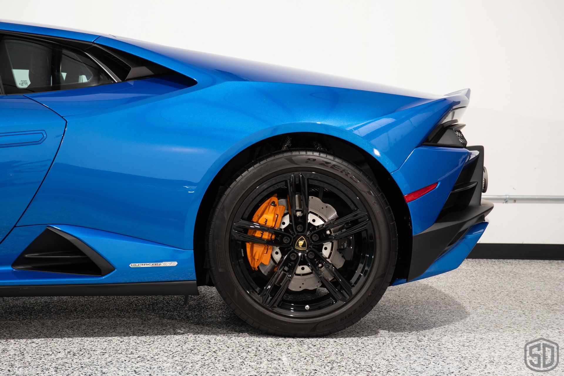 A blue lamborghini huracan is parked in a garage.