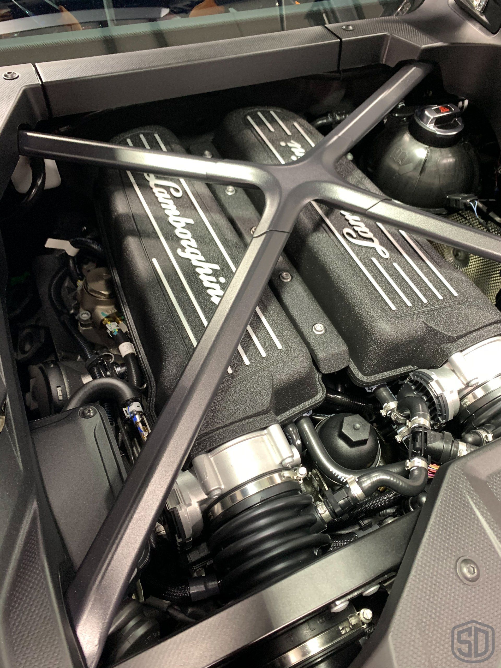 A close up of a lamborghini engine in a car.
