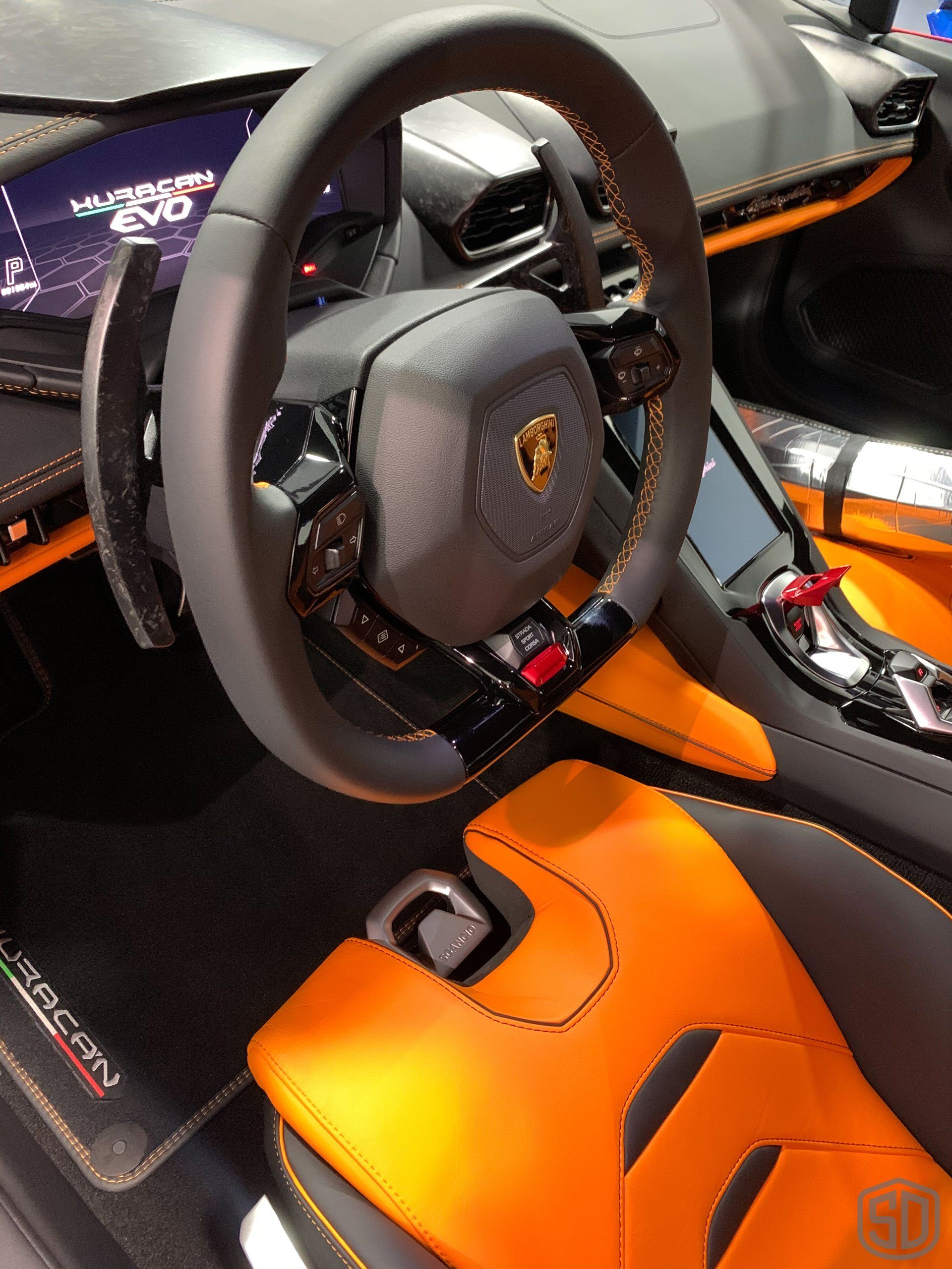 The steering wheel of a lamborghini is shown