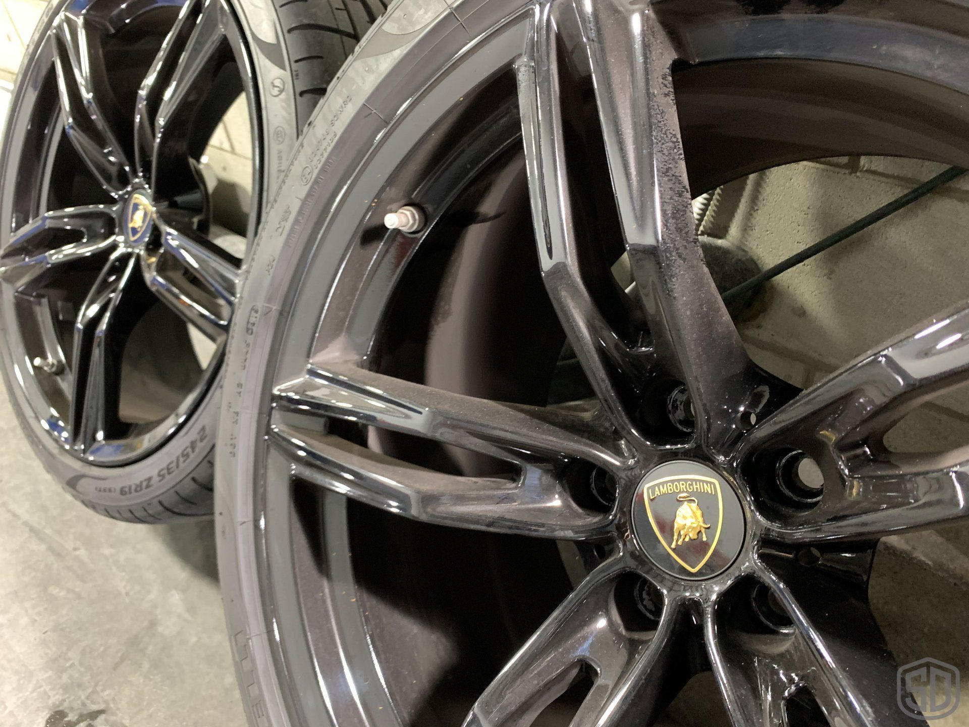 A pair of black wheels with a lamborghini logo on them