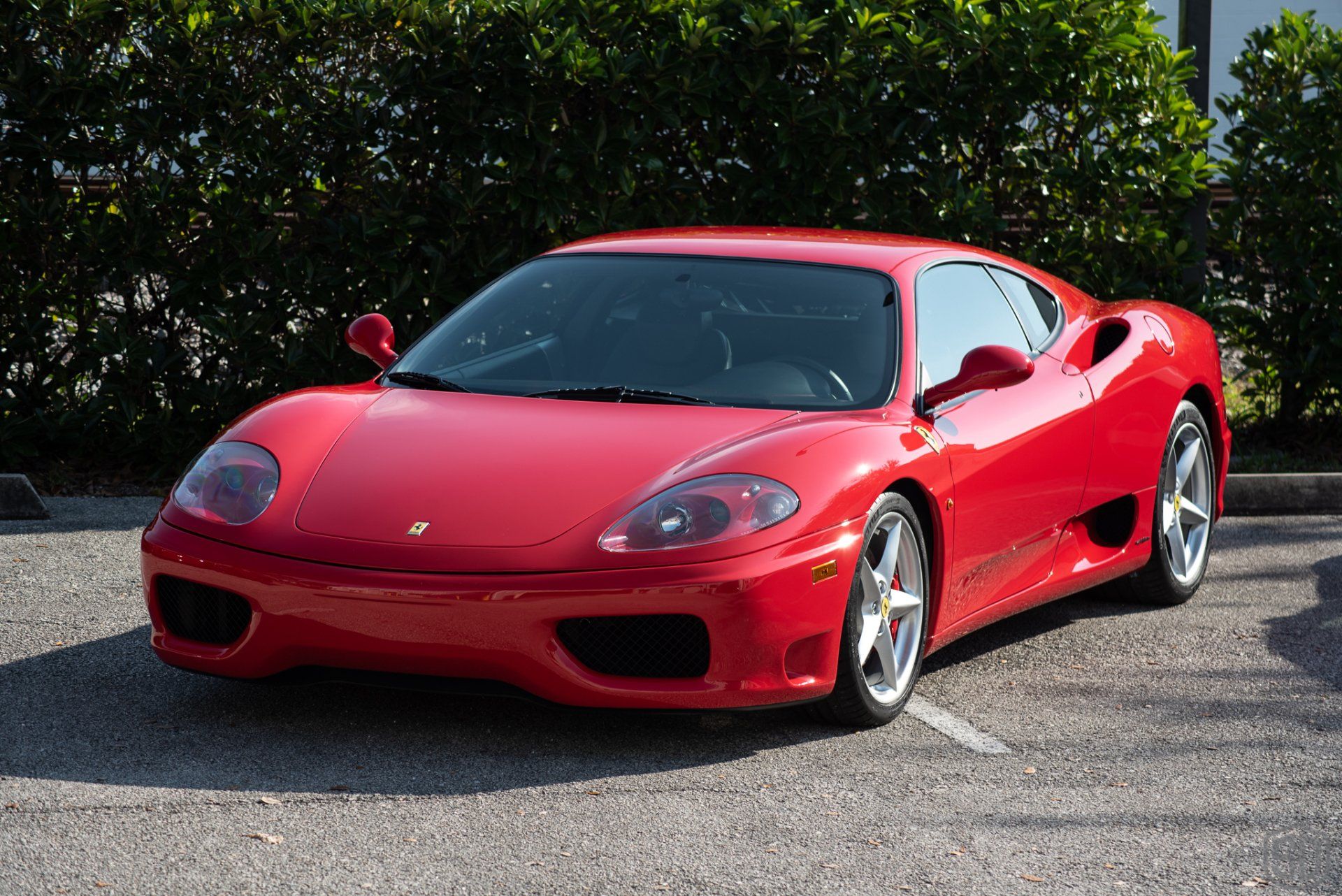 A red sports car is parked in a parking lot.