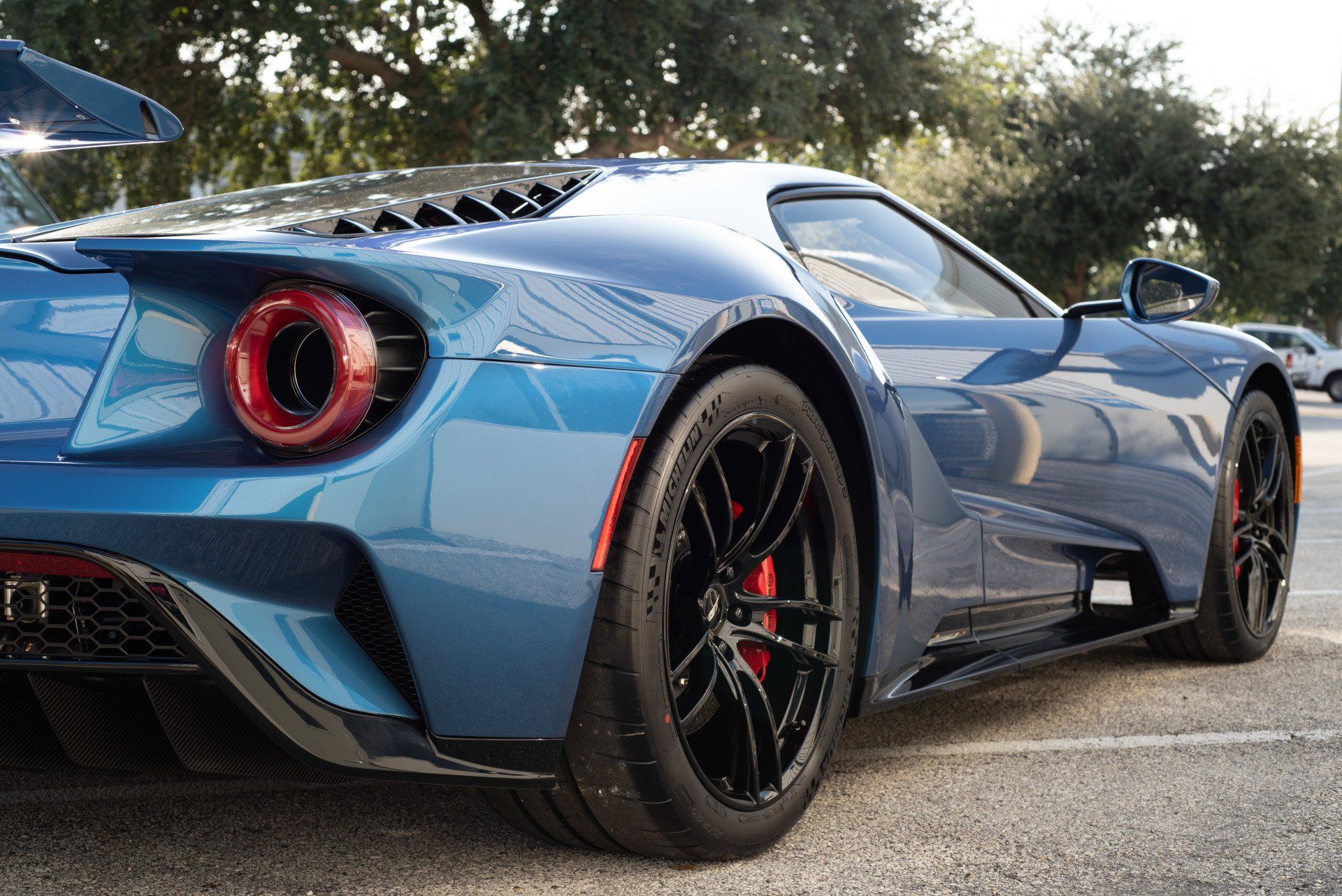 A blue ford gt is parked in a parking lot.