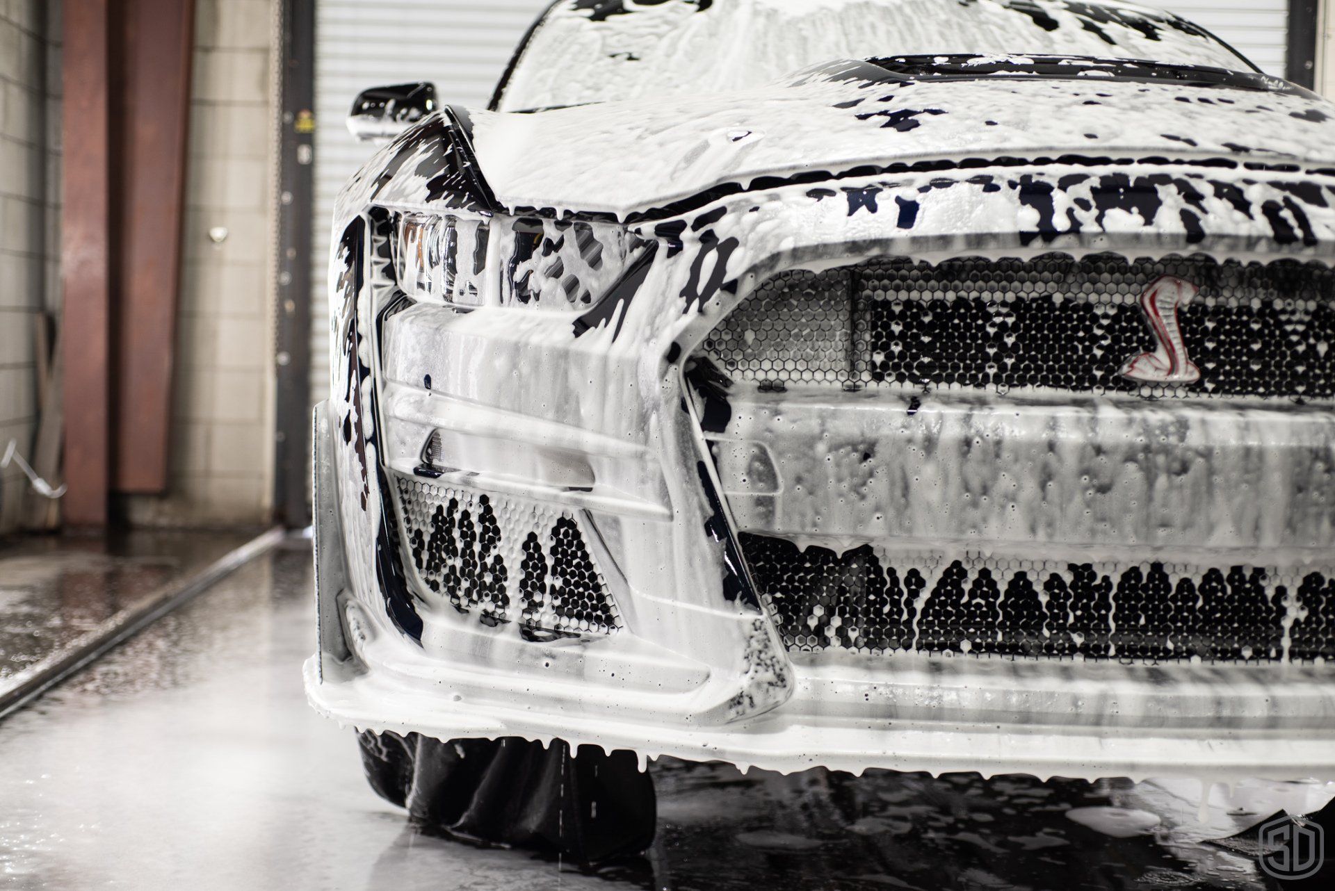 A car is covered in foam at a car wash.