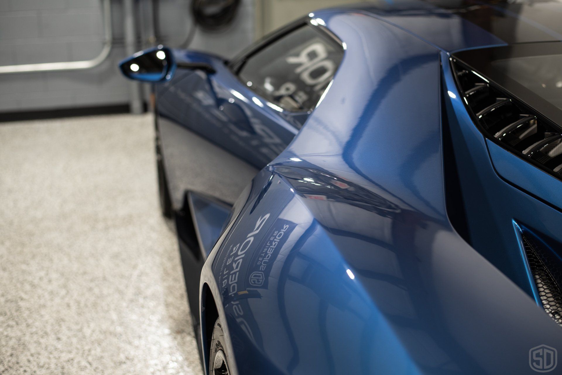 A blue sports car is parked in a garage.