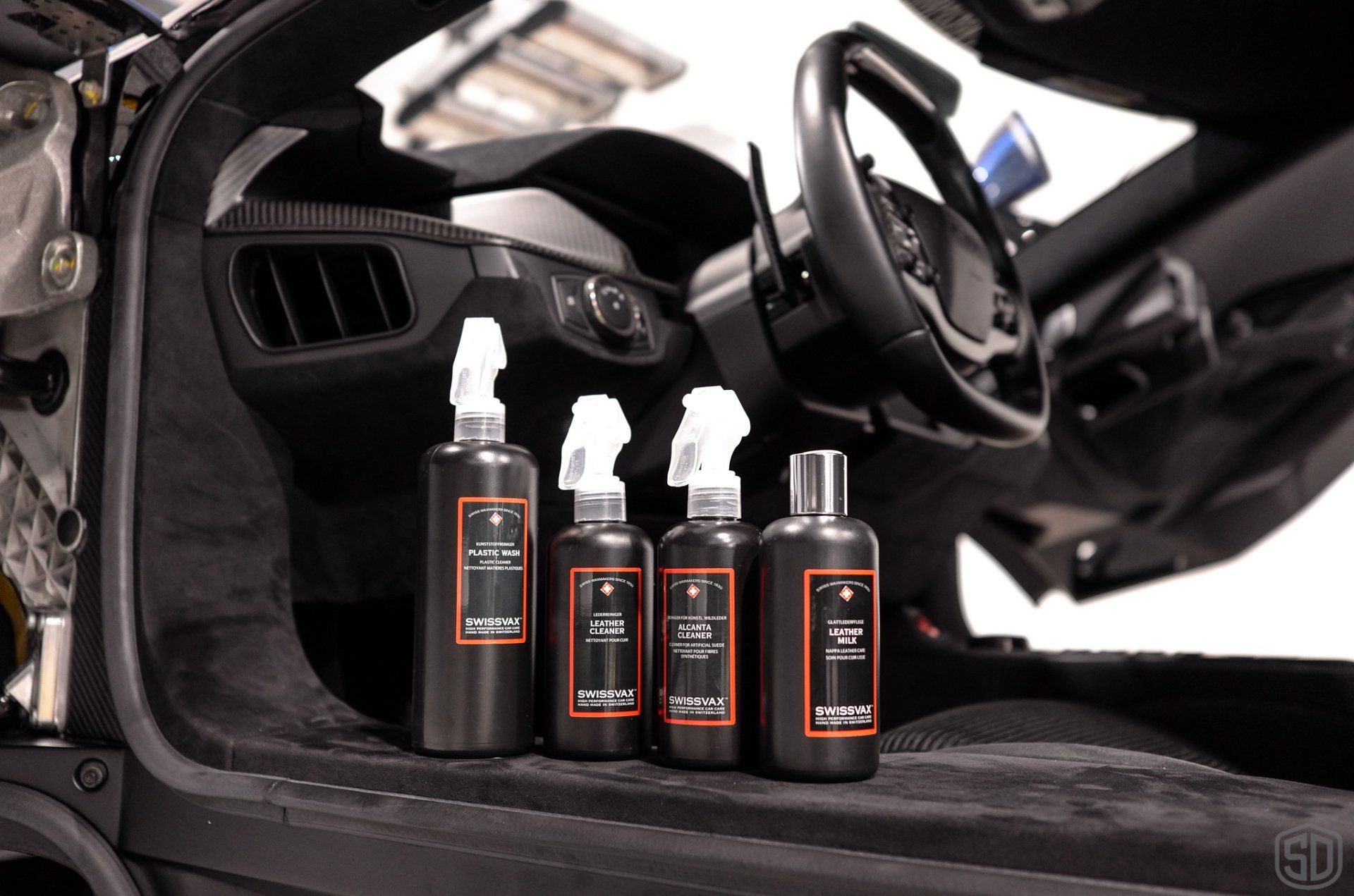 Three spray bottles are sitting inside of a car.