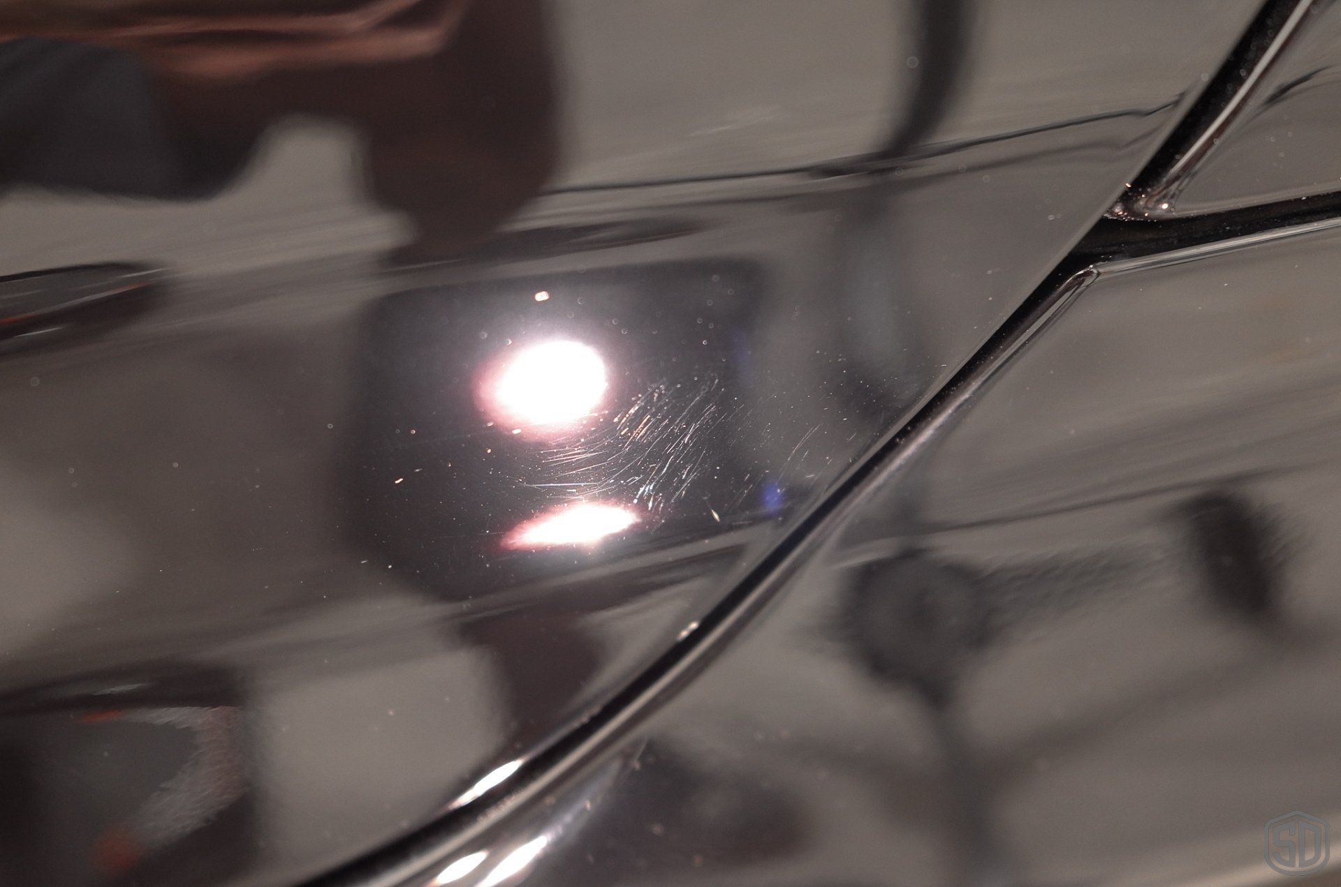 A close up of a black car with a light on it.