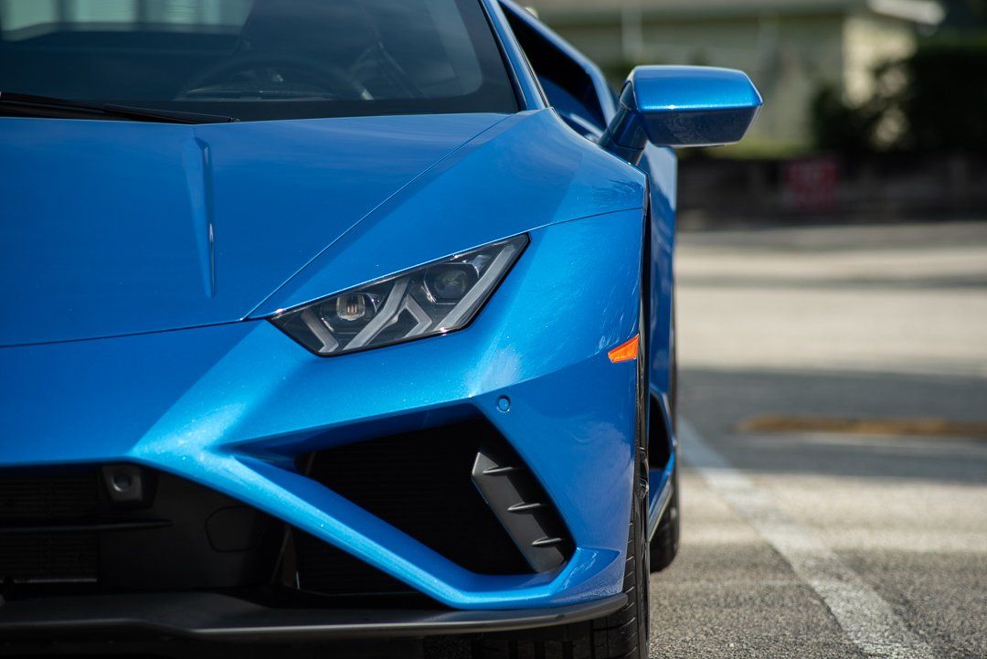 A blue lamborghini huracan is parked on the side of the road.
