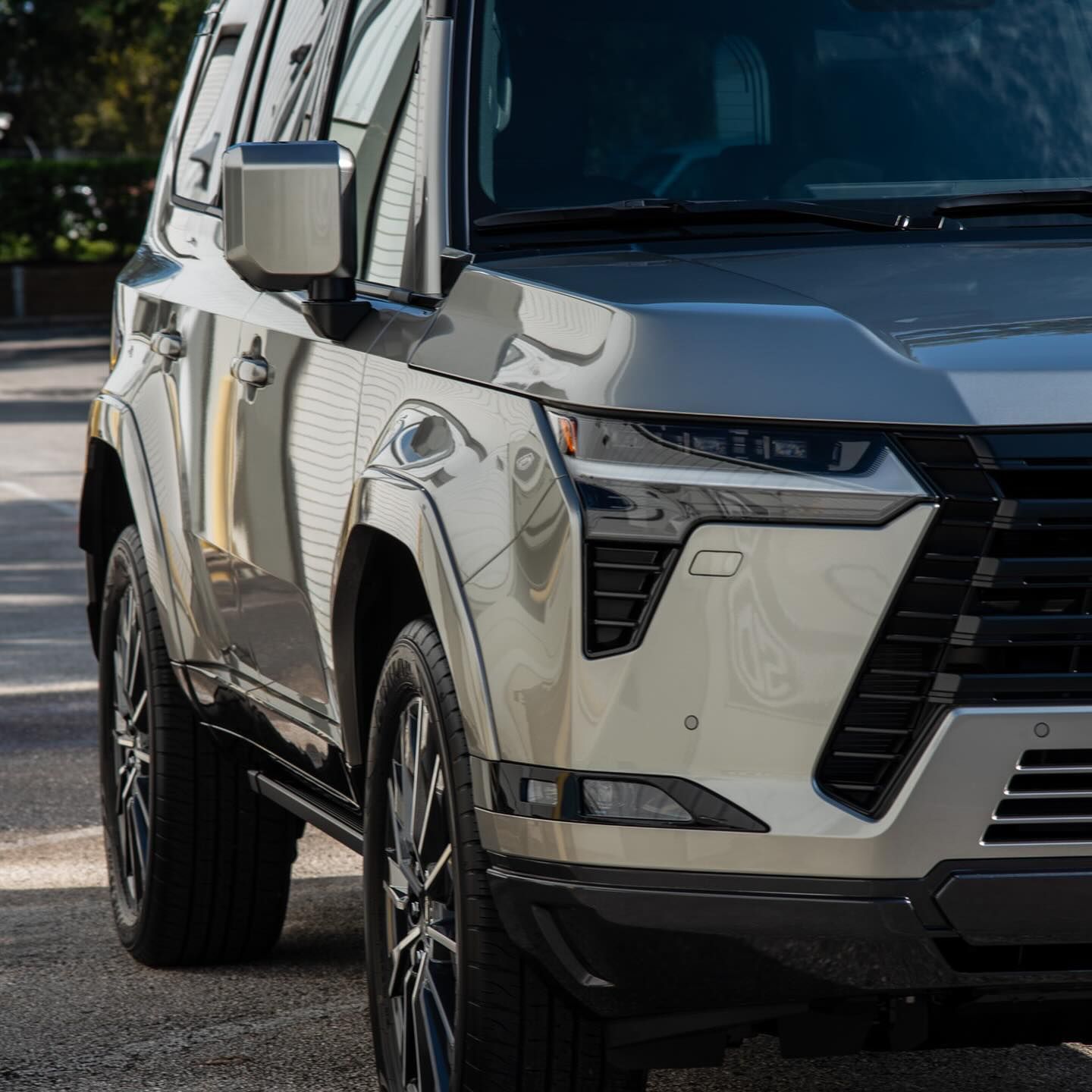 A silver suv is parked on the side of the road.