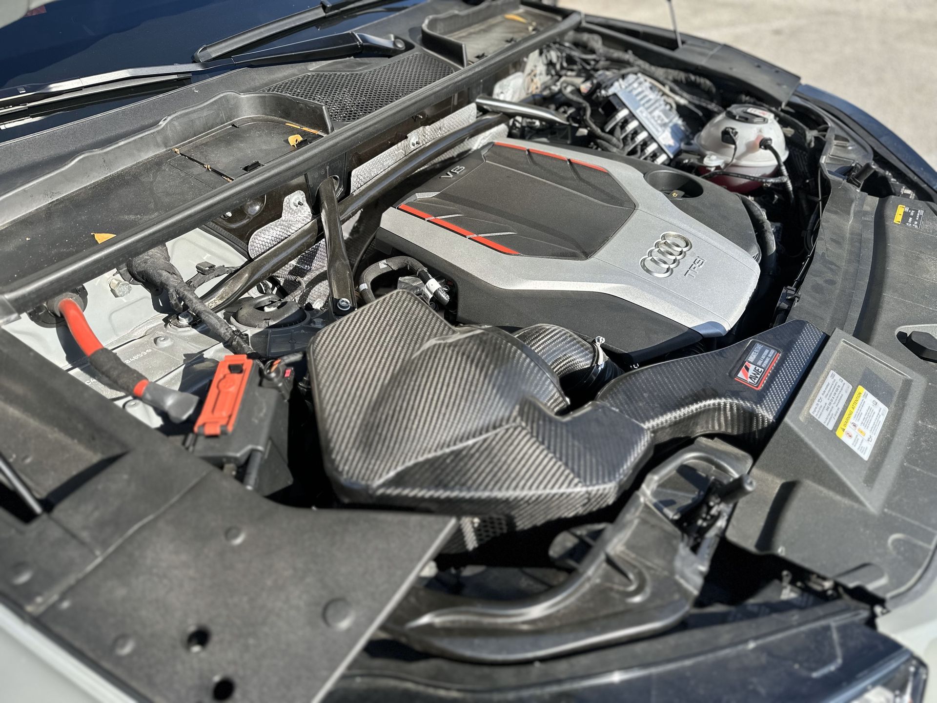 A close up of a car engine with the hood open