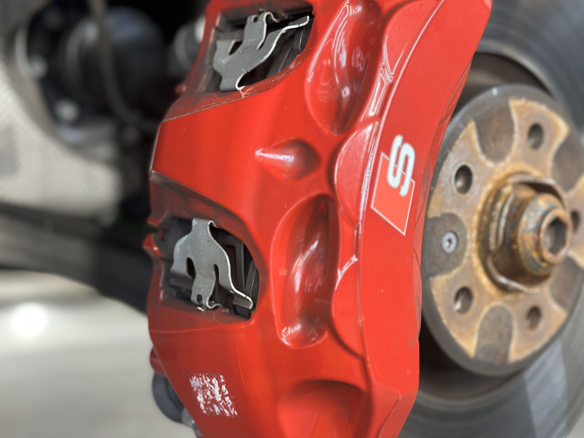 A red brake caliper with the letter s on it