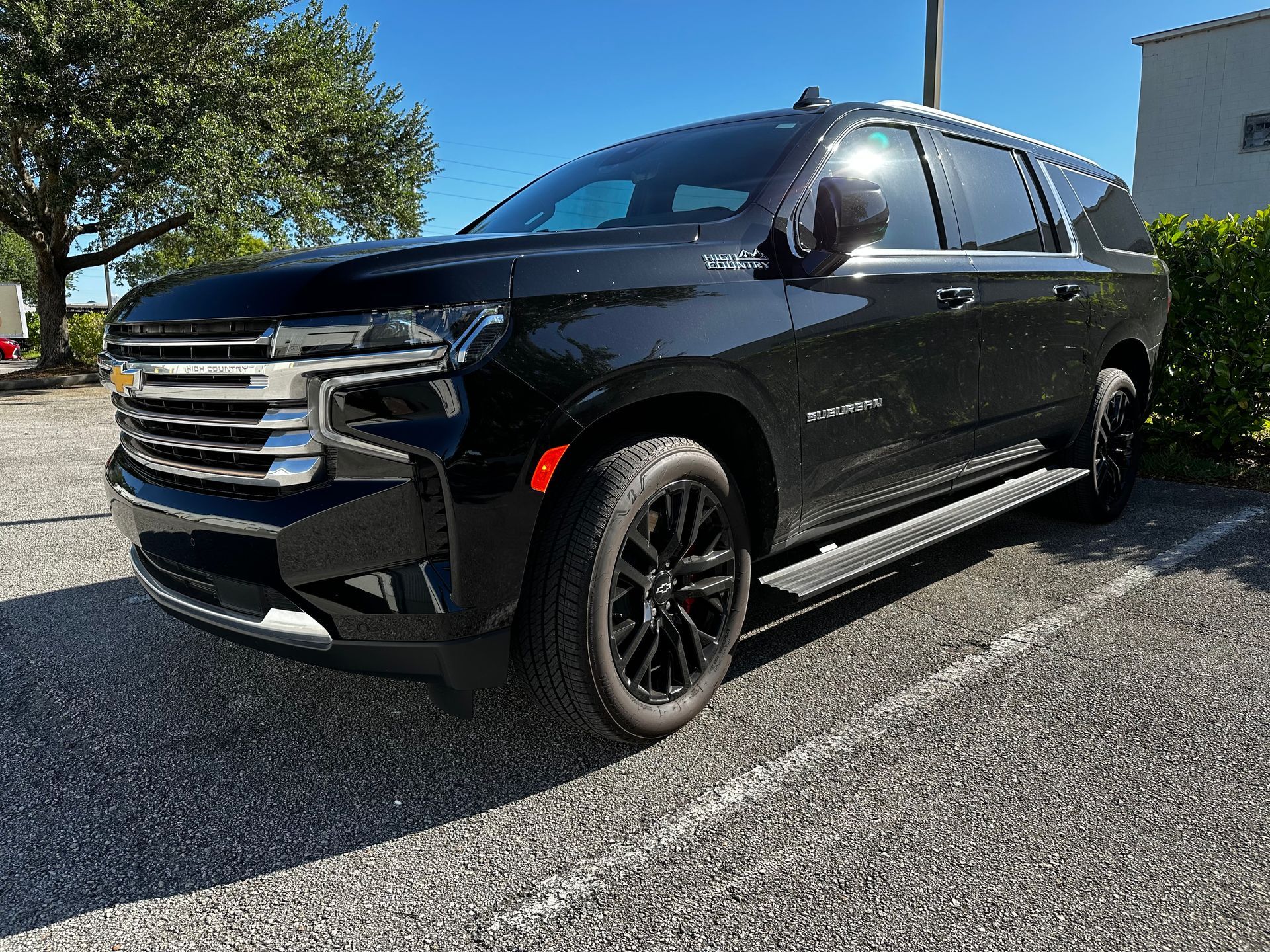 A black suv is parked in a parking lot.