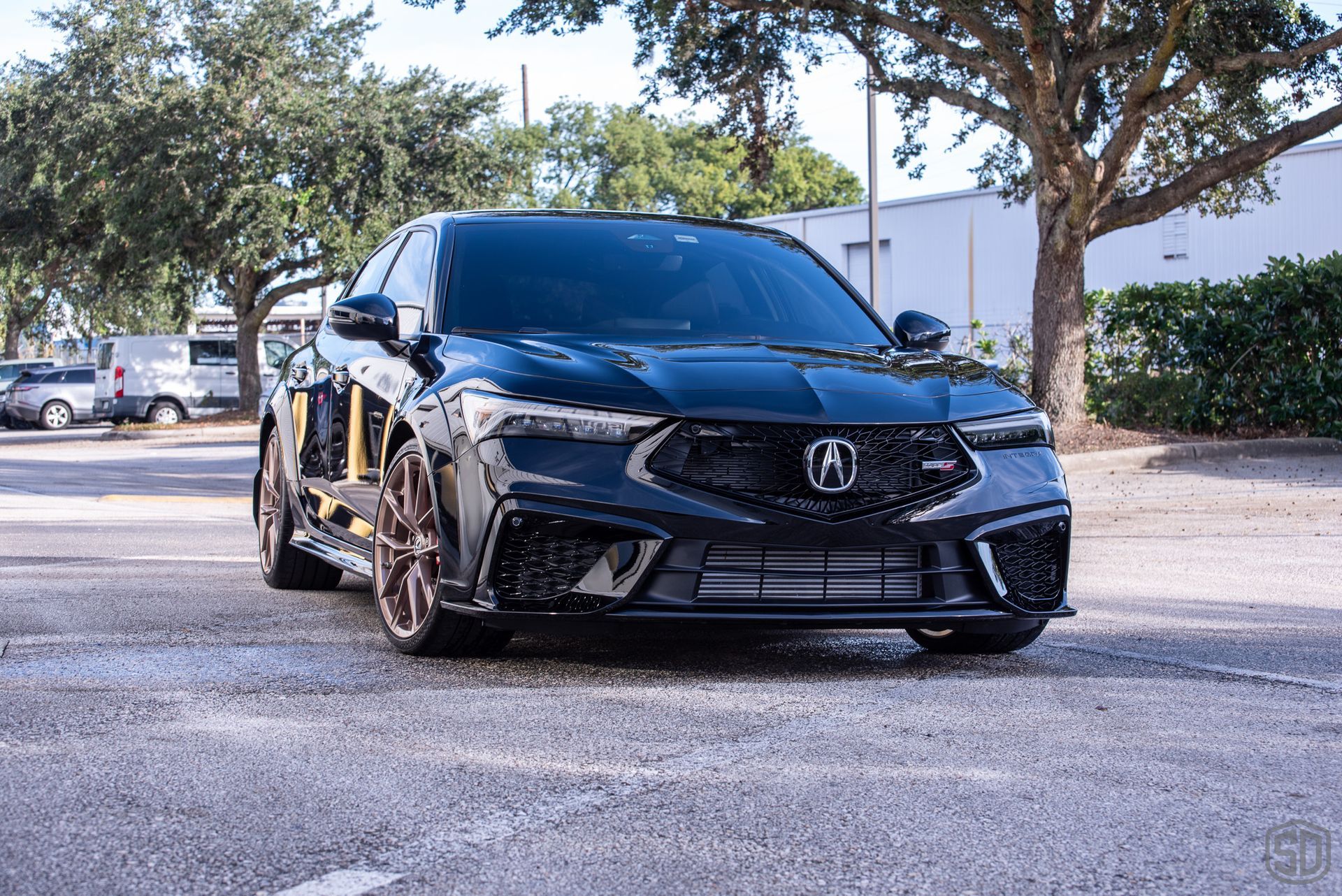 A black acura integra is parked in a parking lot.