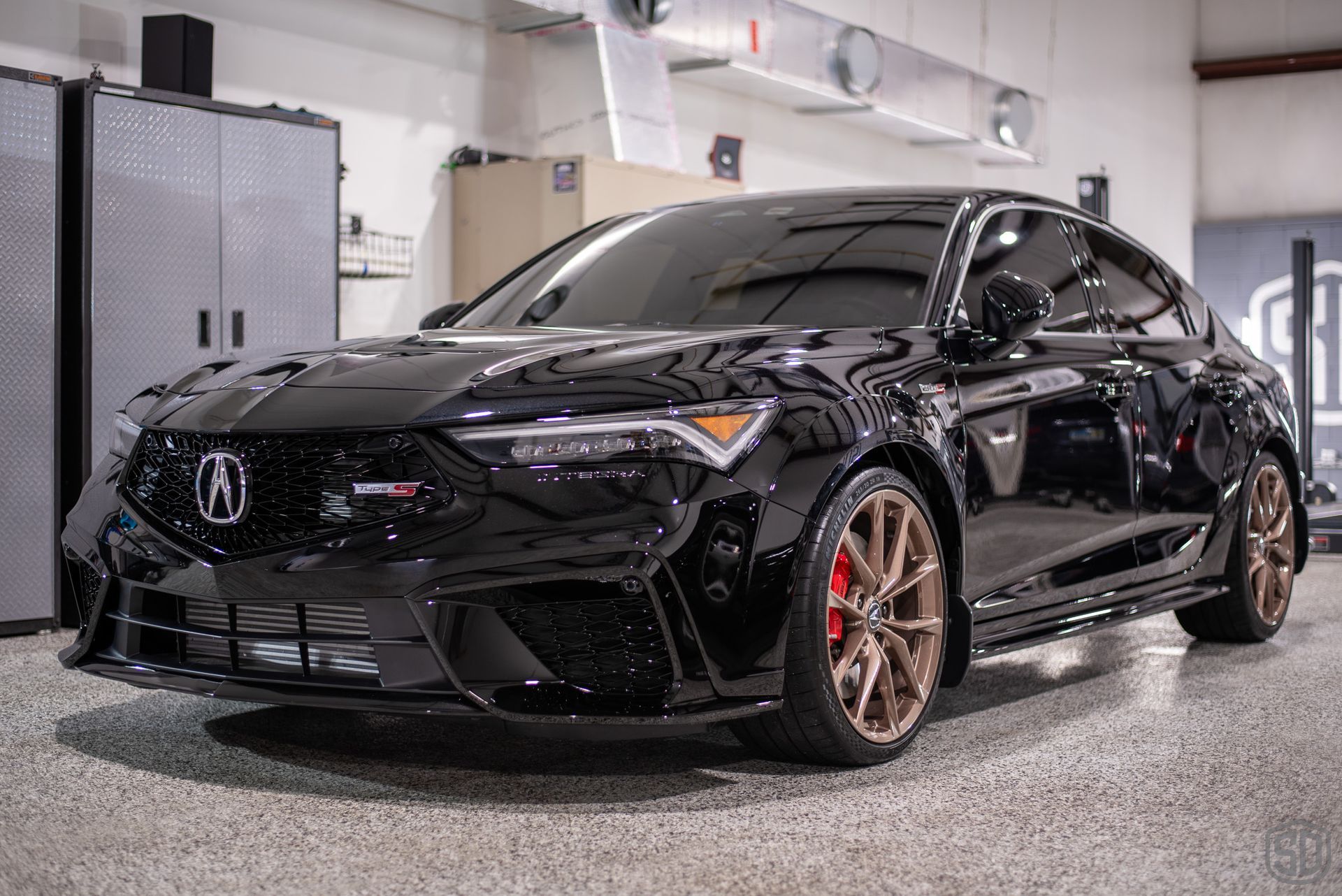 A black acura integra is parked in a garage.