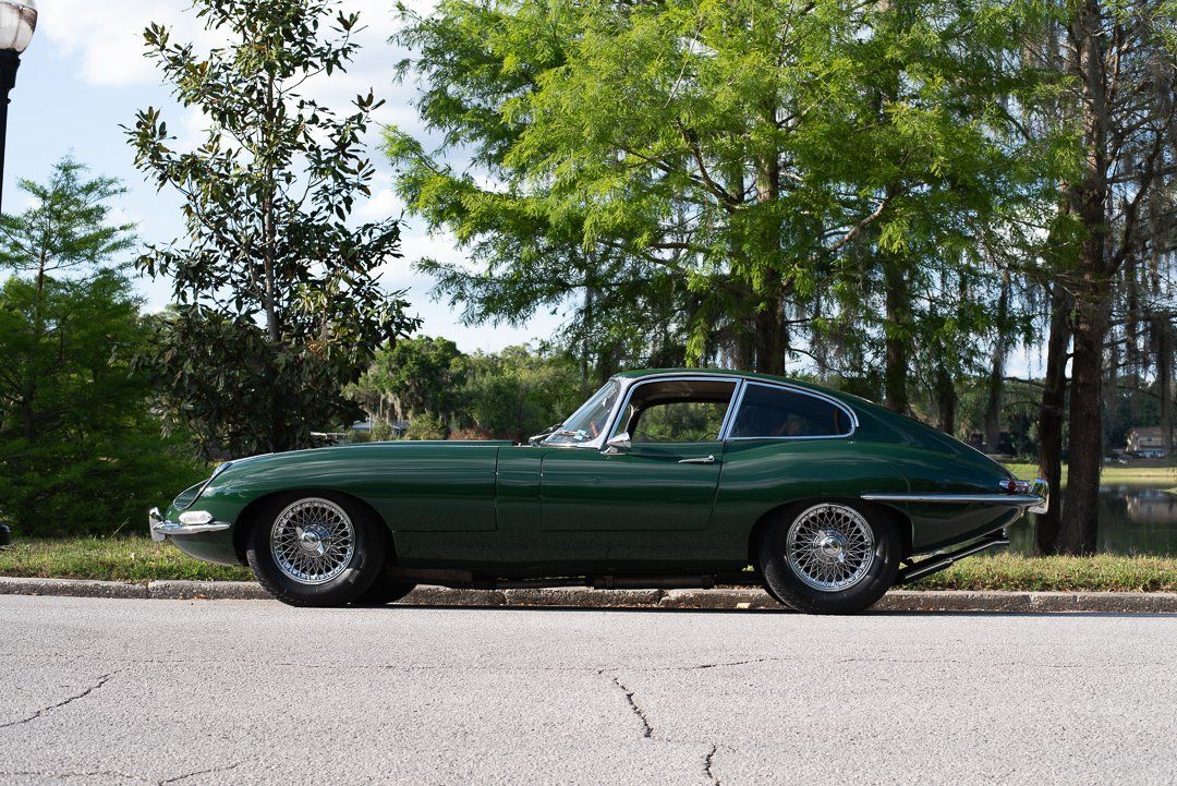 A green sports car is parked on the side of the road.