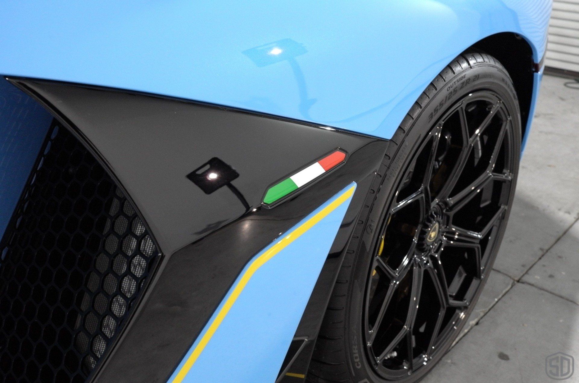 A close up of a blue sports car with a black tire
