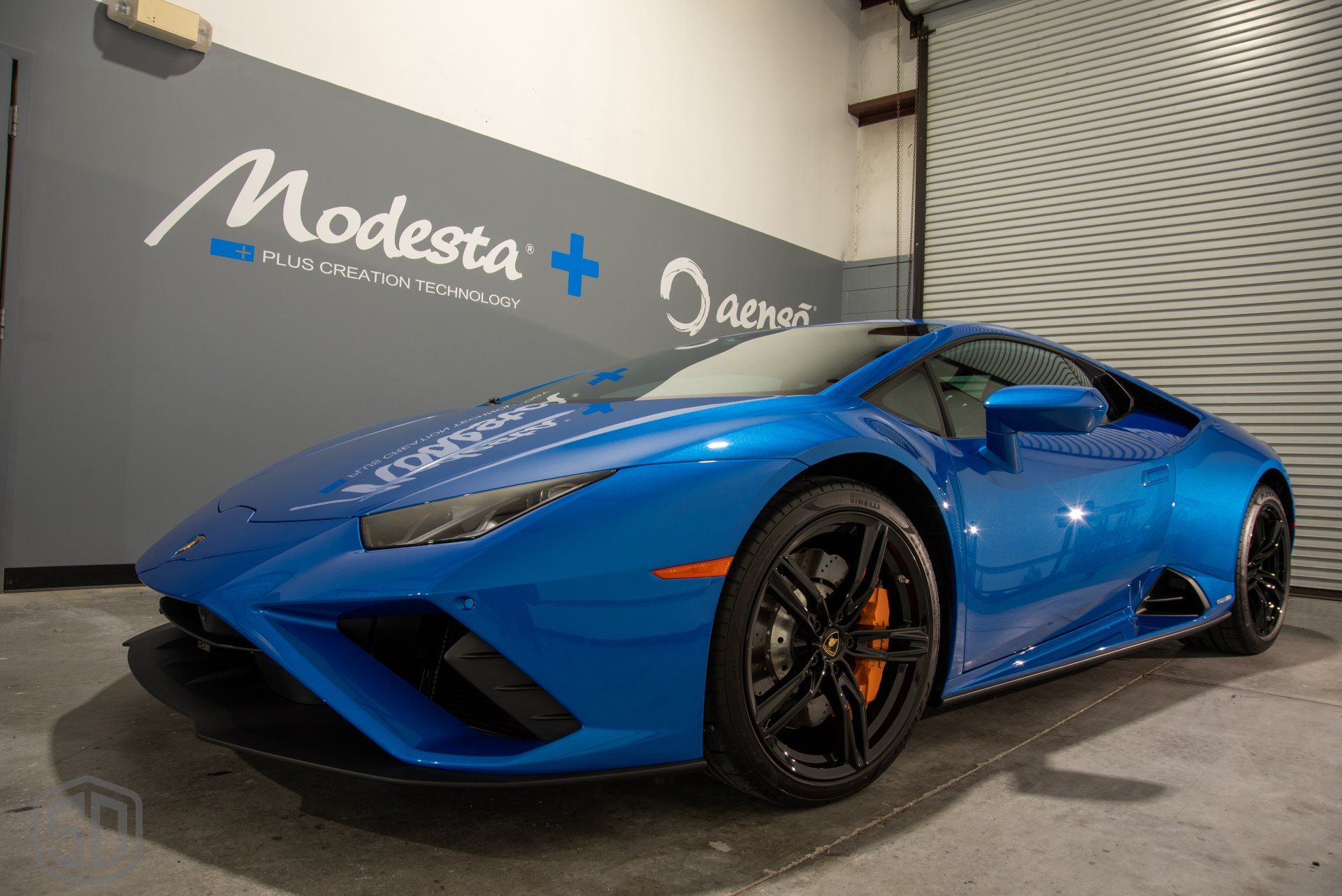 A blue lamborghini huracan is parked in a garage.