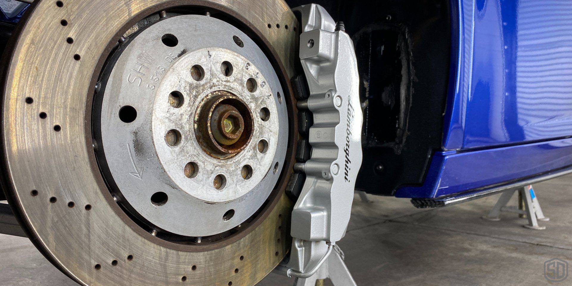 A close up of a brake disc on a blue car.