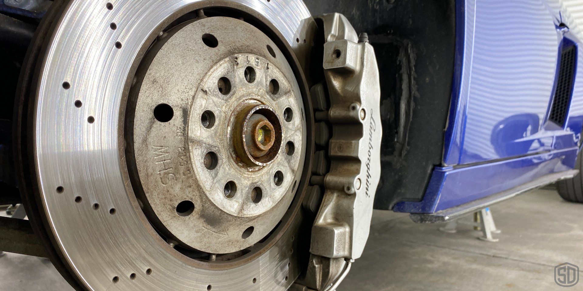 A close up of a brake disc on a blue car.