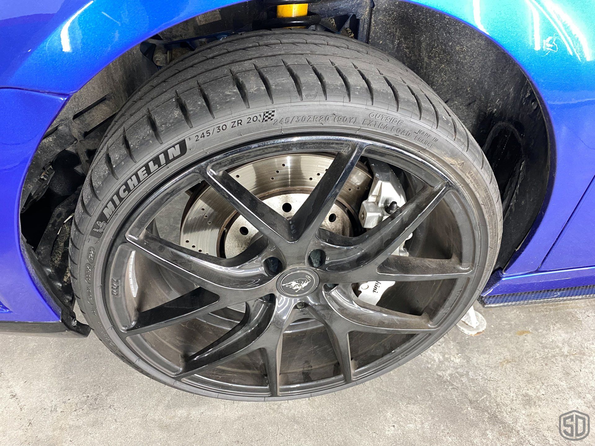 A blue car with a black tire on it.