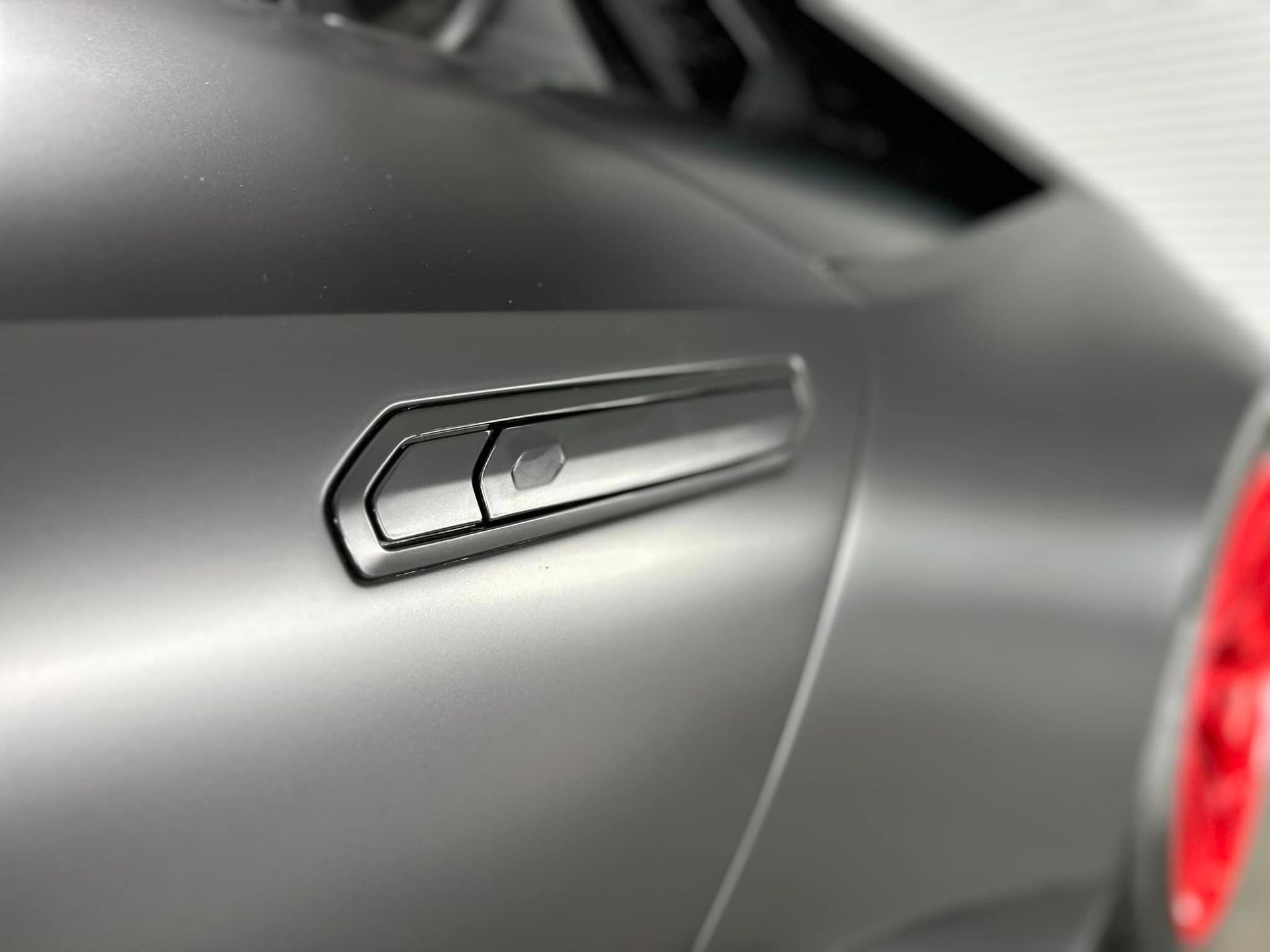 A close up of a car door handle on a black car