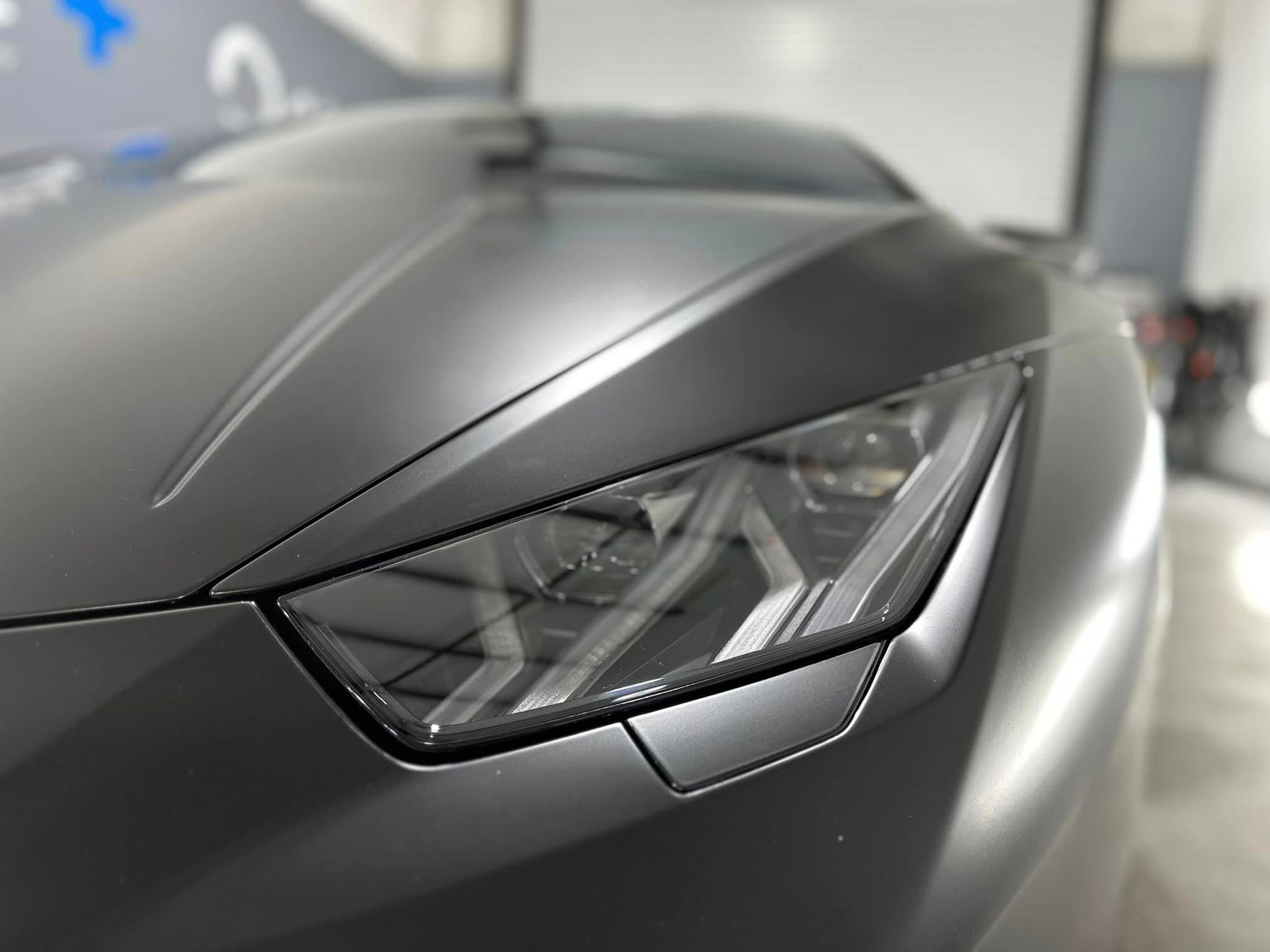 A close up of a car 's headlight in a garage.