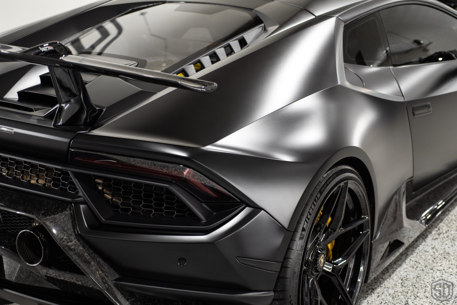 A black lamborghini huracan is parked in a garage.