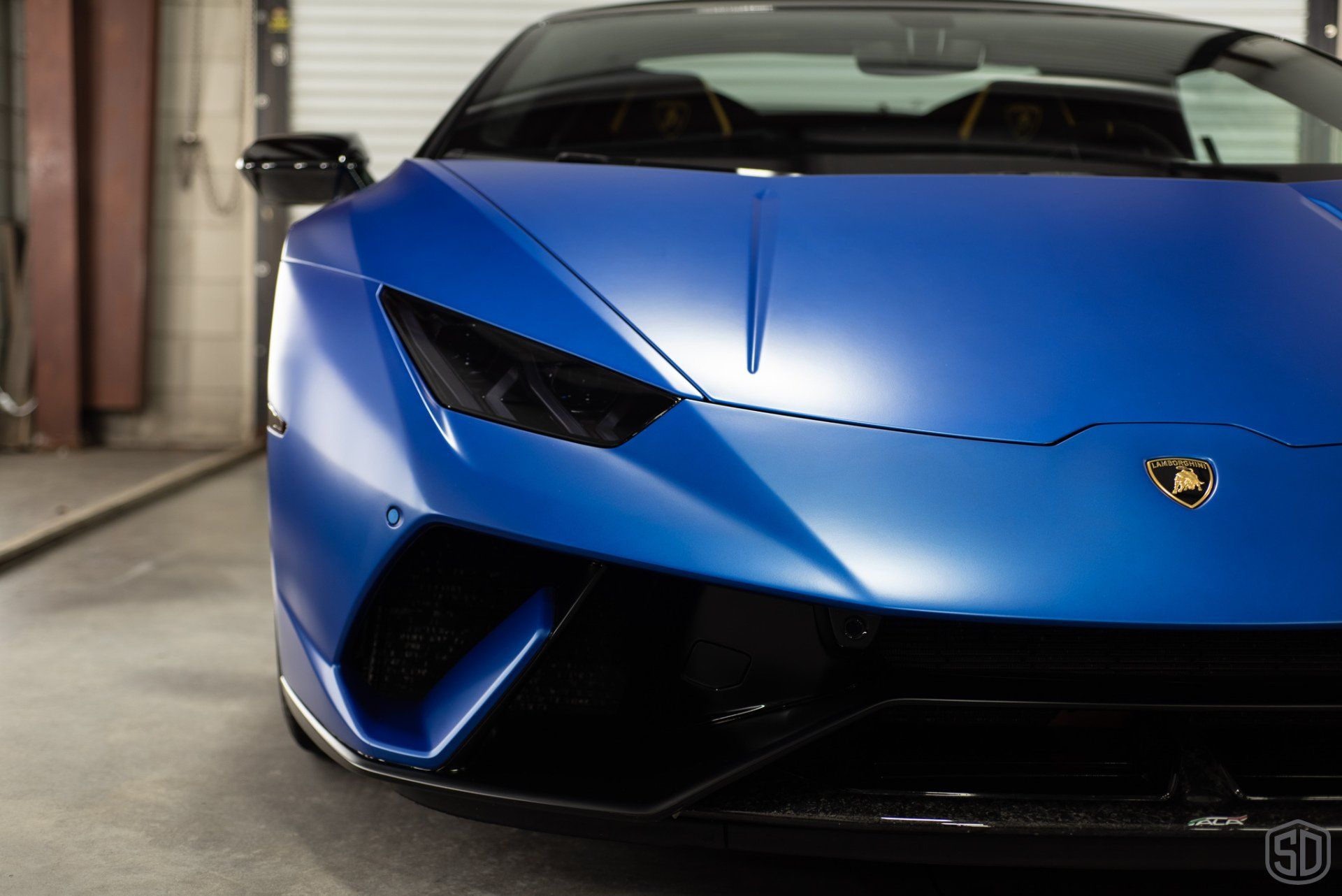 A blue lamborghini is parked in a garage