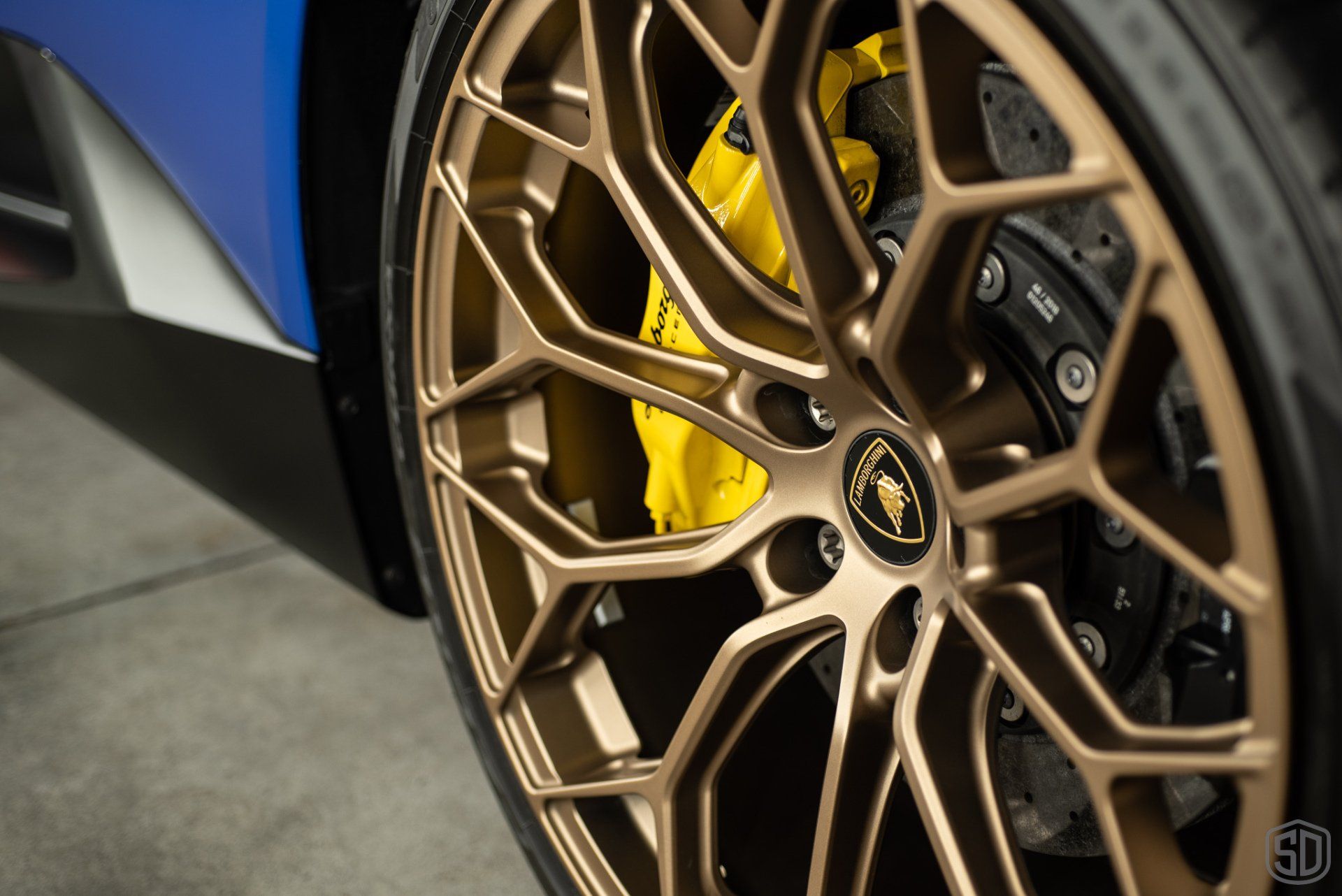 A close up of a car wheel with a yellow brembo brake caliper.
