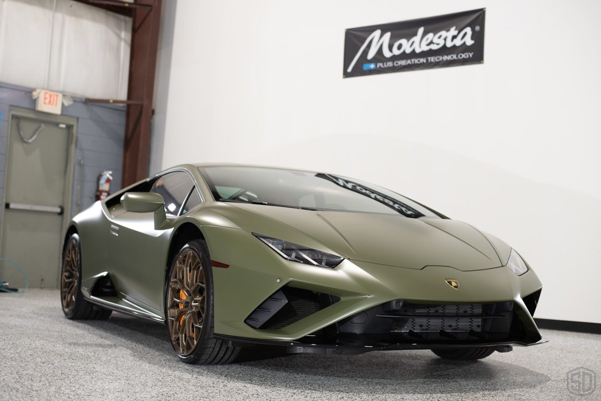 A green lamborghini huracan is parked in a garage.