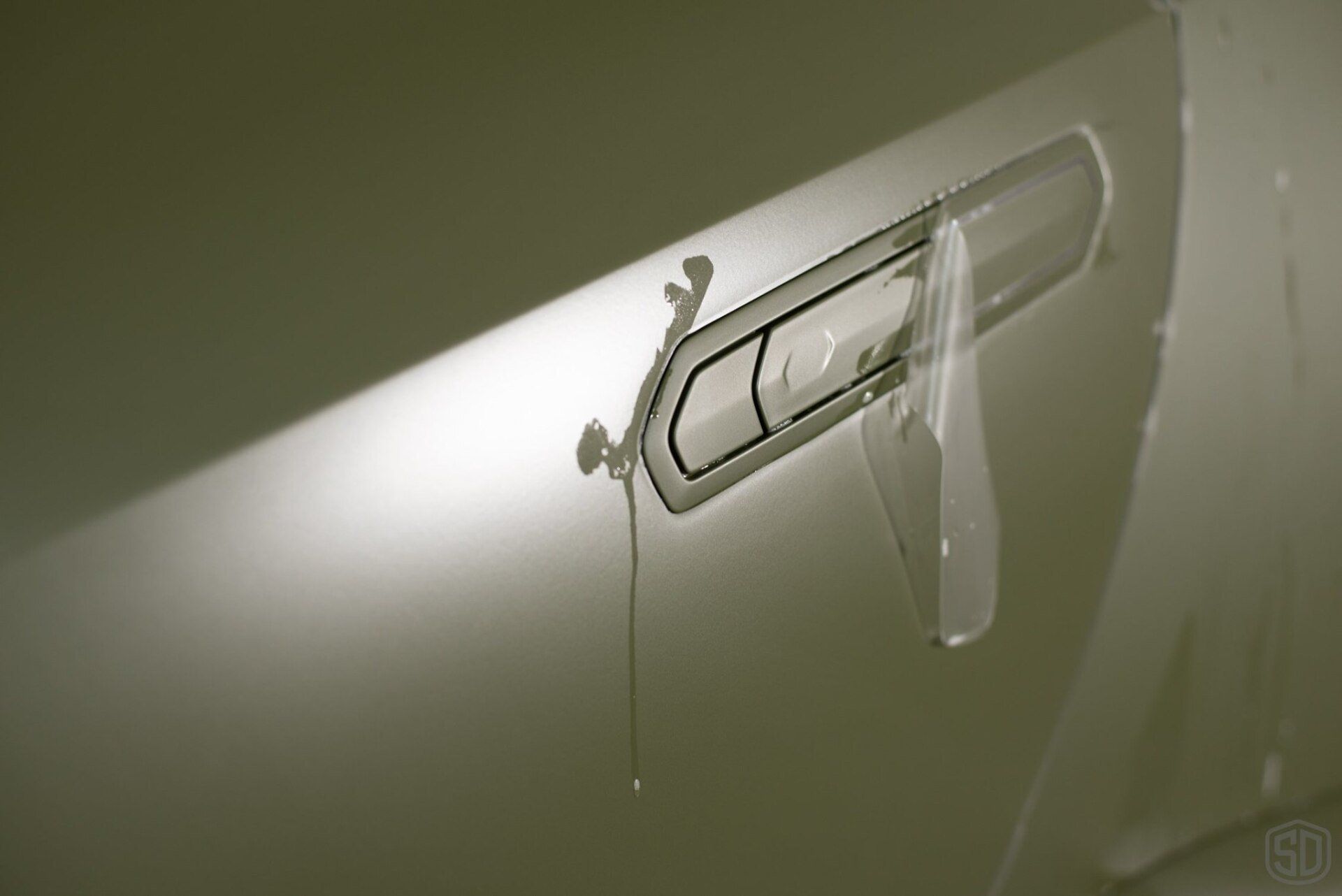 A close up of a car door with a paper clip on it