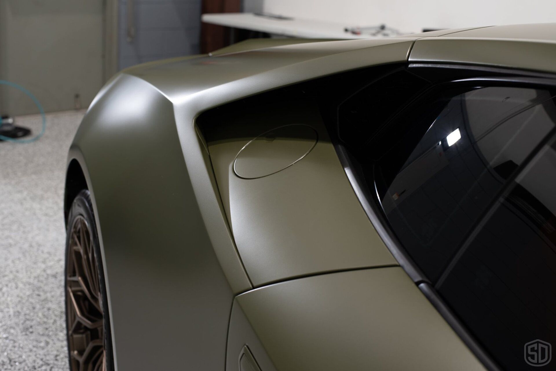 A green sports car is parked in a garage