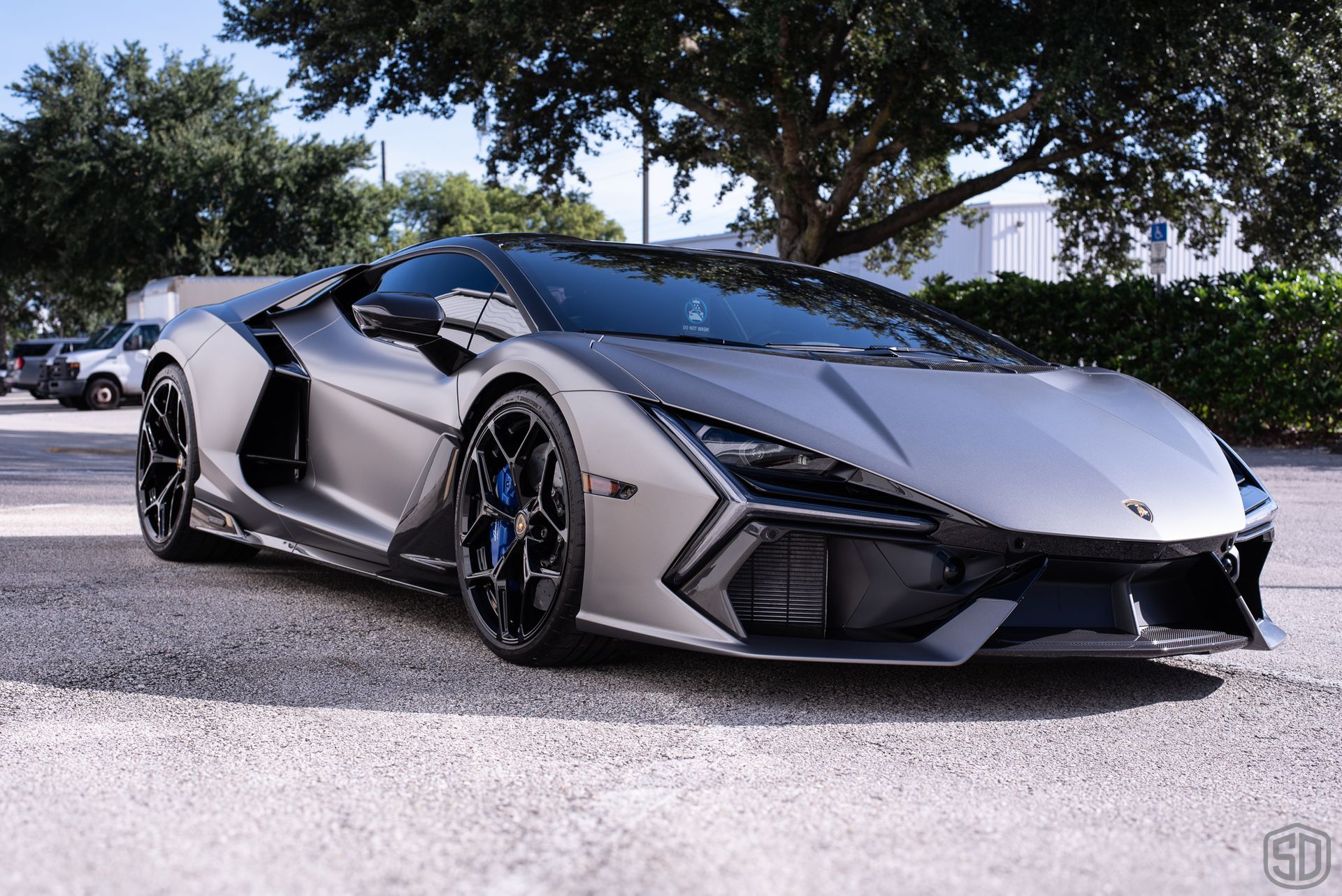 Silver Lamborghini sports car parked outside.
